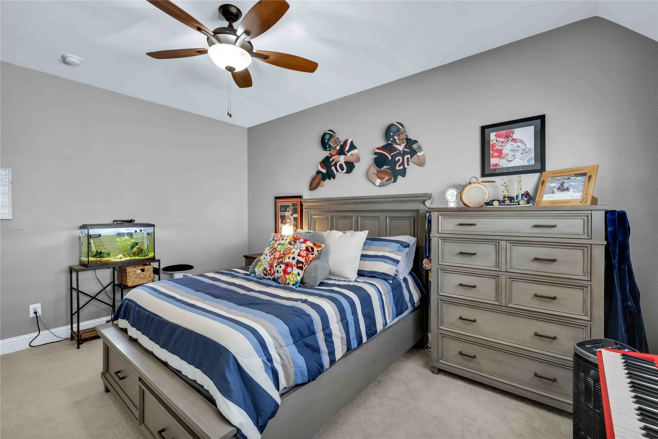 Bedroom featuring light gray wall paint, a ceiling fan with light fixture, and carpet flooring