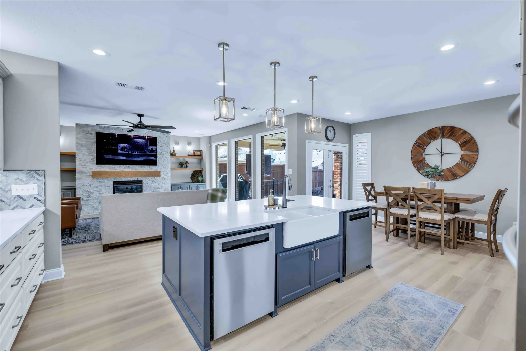 Modern kitchen island with farmhouse sink, integrated dishwasher, and pendant lighting