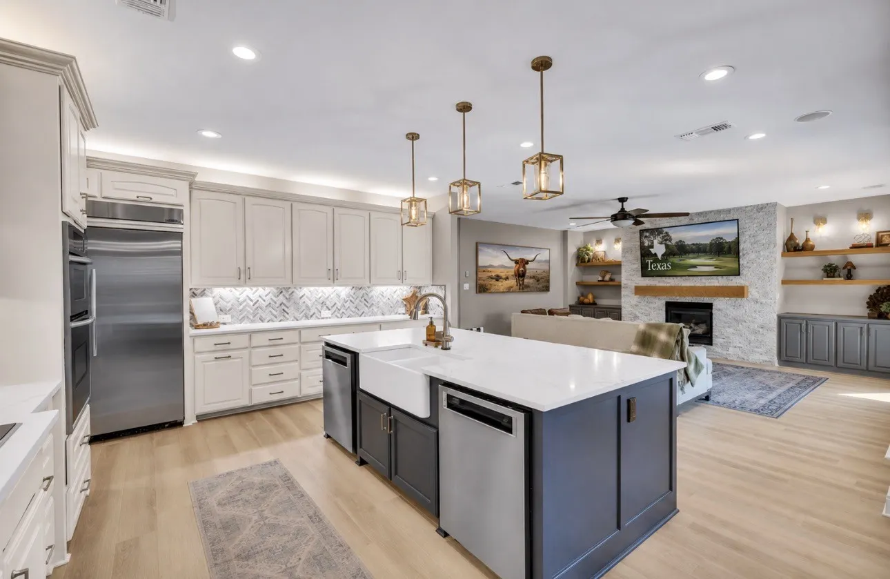 Open-concept living area featuring a kitchen with a large island, stainless steel appliances, and light-toned cabinetry