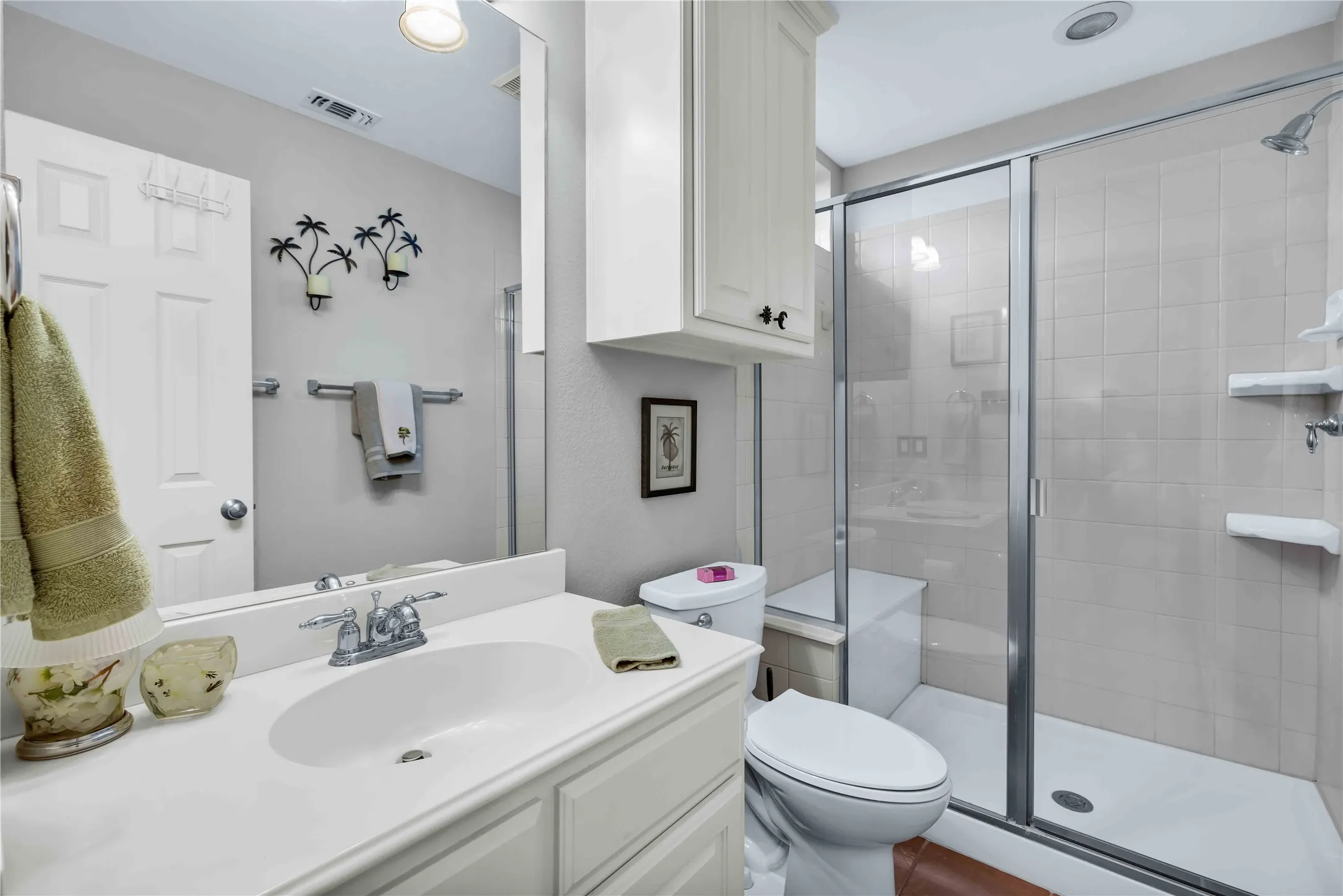 Bathroom featuring a white vanity with integrated sink, chrome faucet, and expansive wall mirror