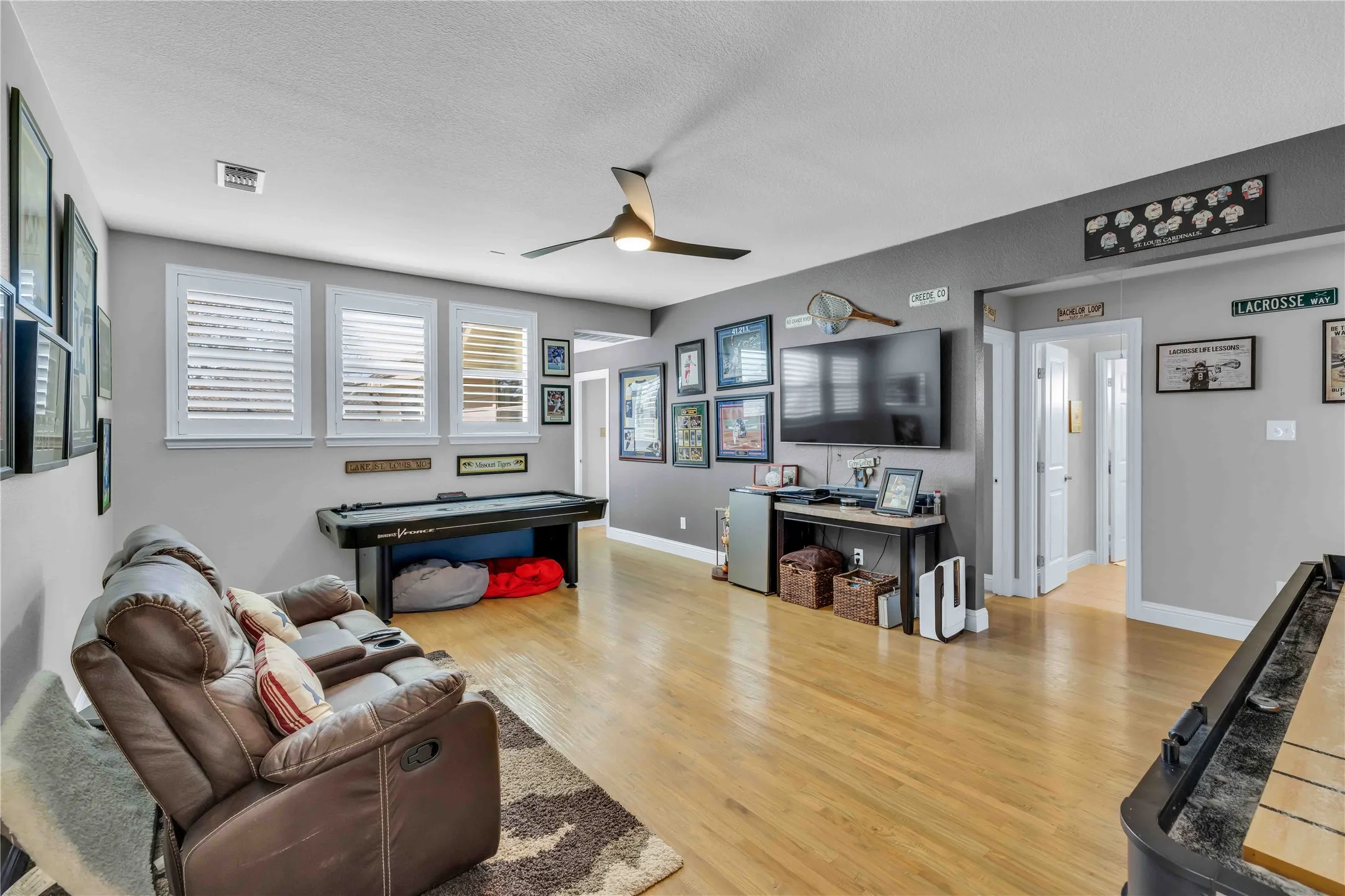 Spacious room featuring light wood-finish flooring and grey-painted walls