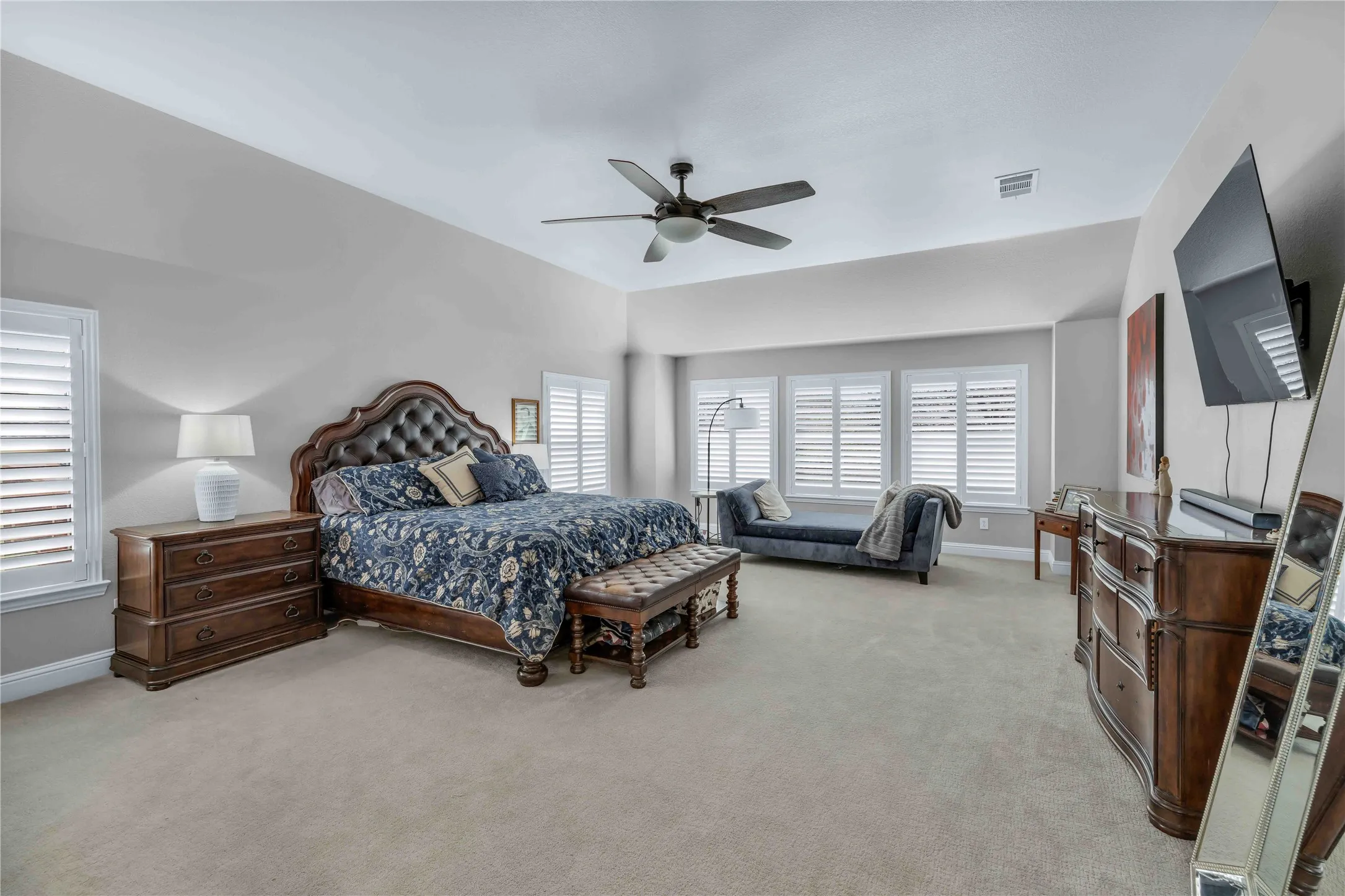 Spacious bedroom featuring neutral carpeting and vaulted ceilings