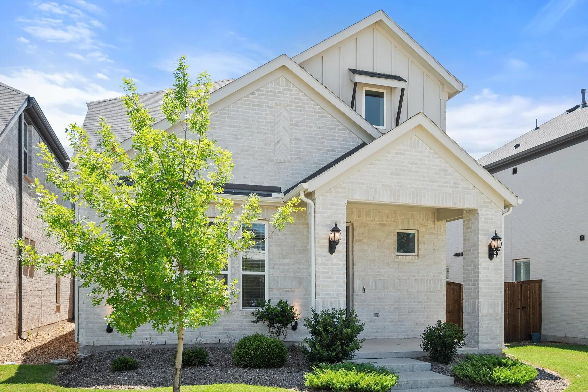 Contemporary exterior featuring light-colored brick and vertical siding accents