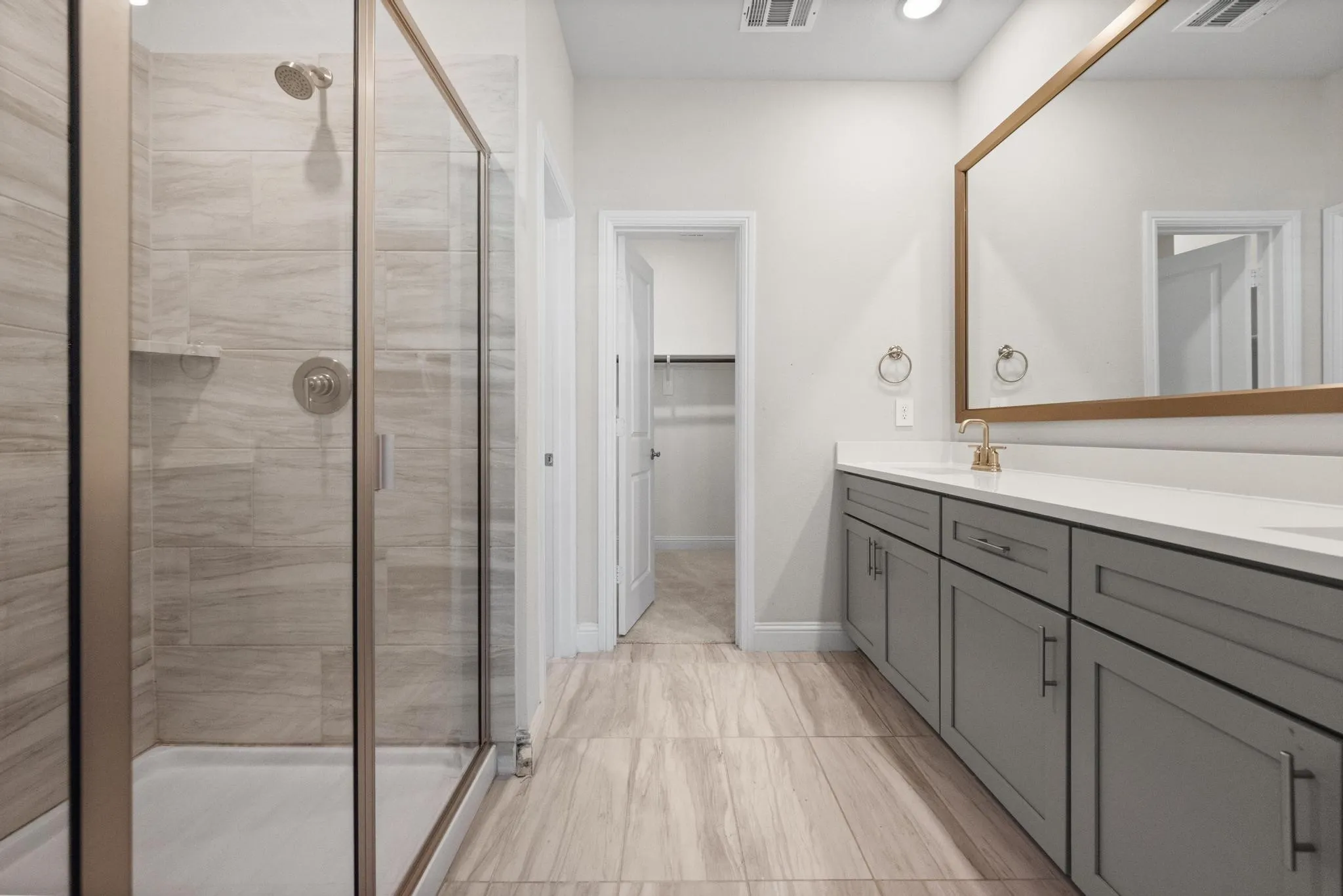 Contemporary bathroom featuring a spacious glass-enclosed shower with tiled walls and a built-in niche