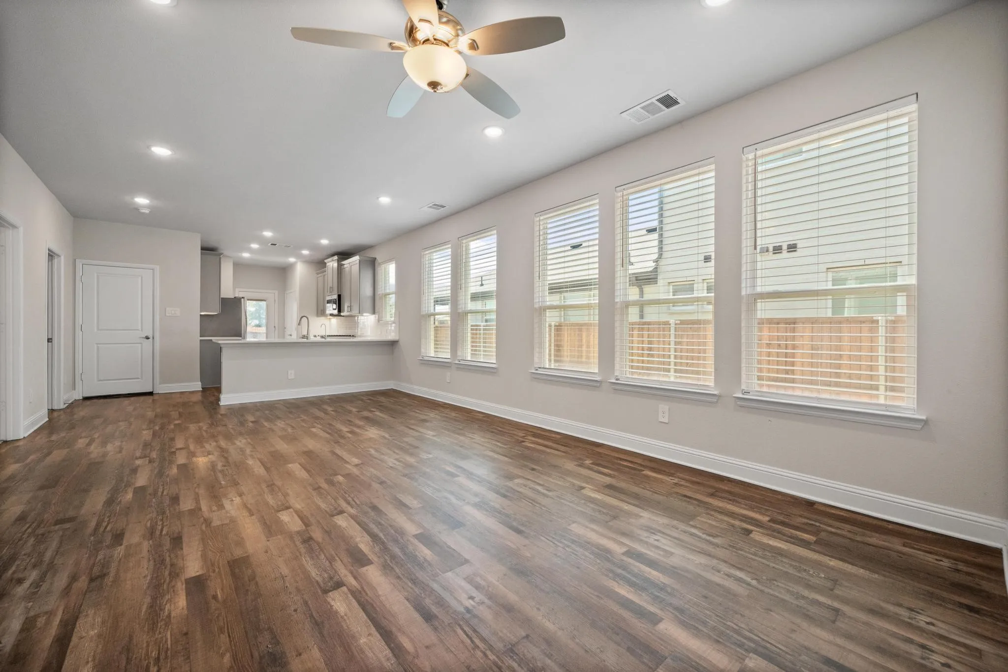 Open-concept living area featuring wood-finish flooring, recessed lighting, and a ceiling fan