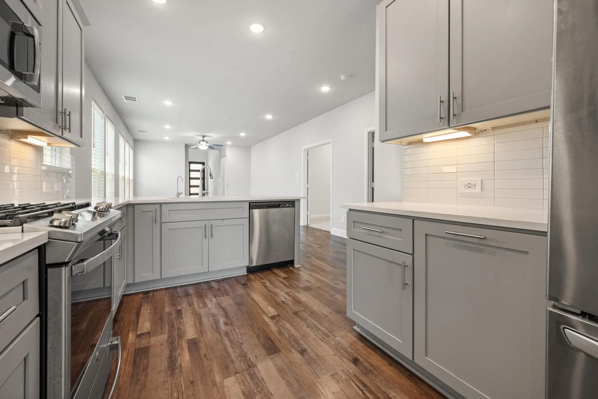 Kitchen with wood-finish flooring, recessed lighting, and light grey cabinetry