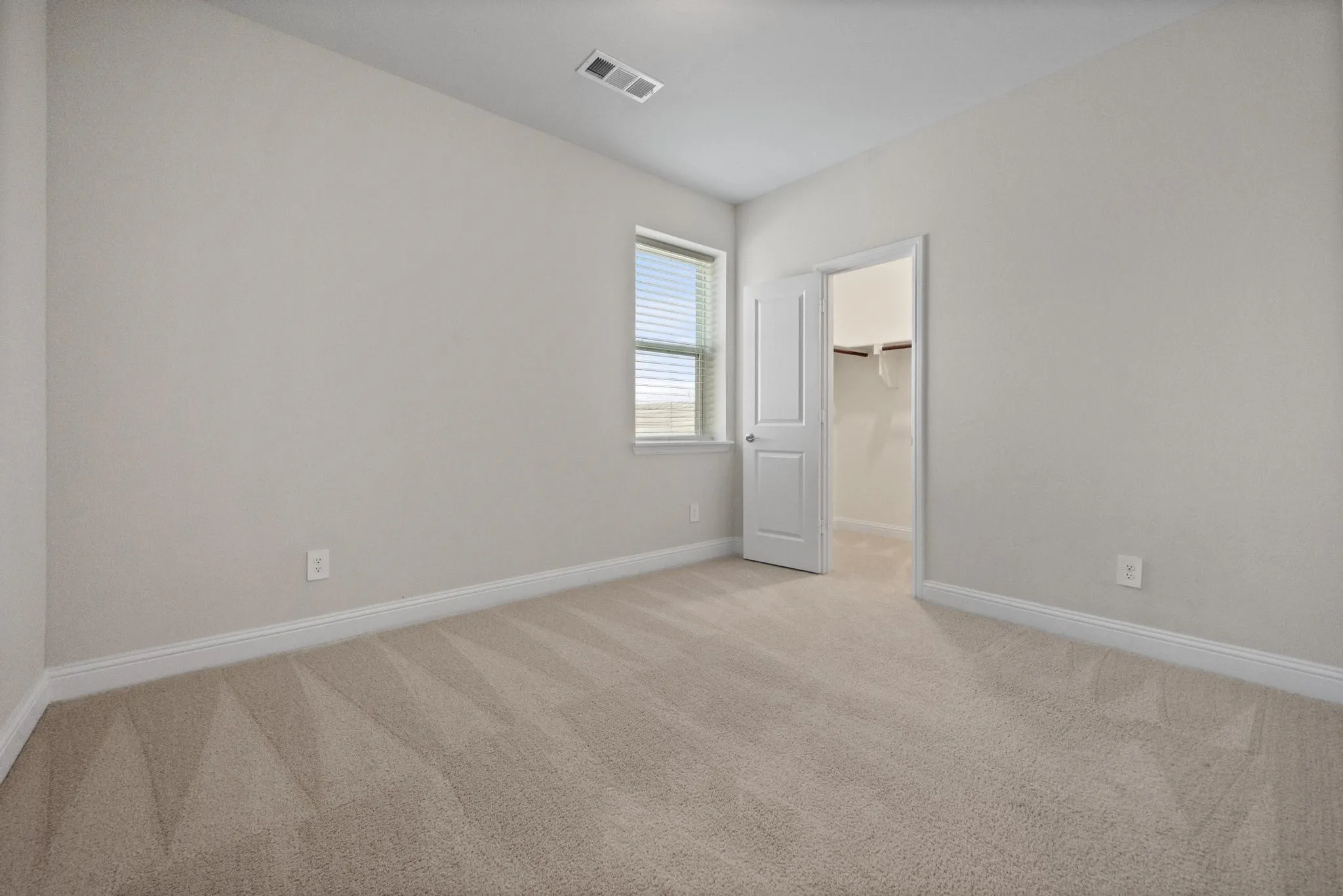 Neutral-toned walls complement plush carpet flooring