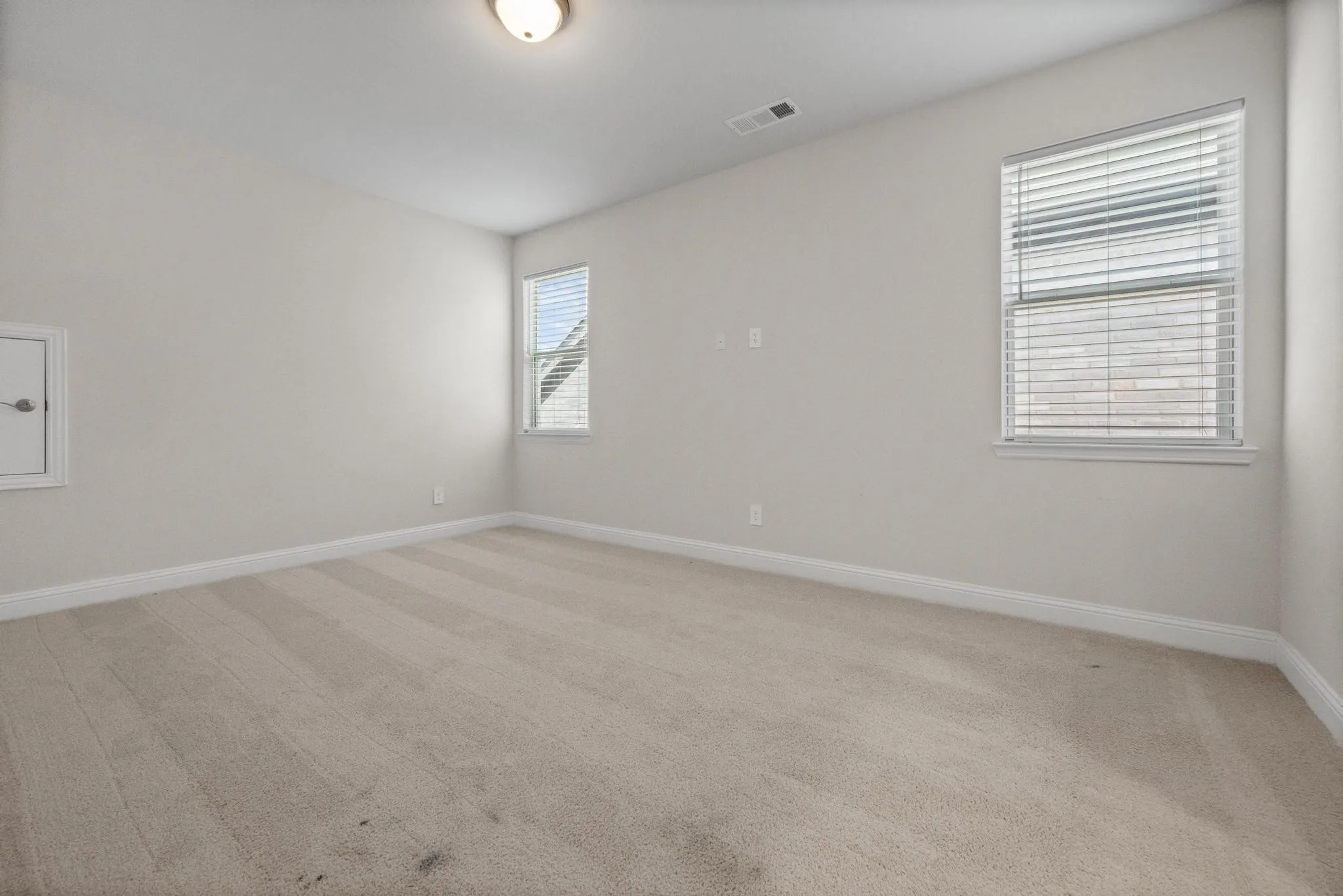 Neutral-toned carpet flooring and light-colored walls define this room