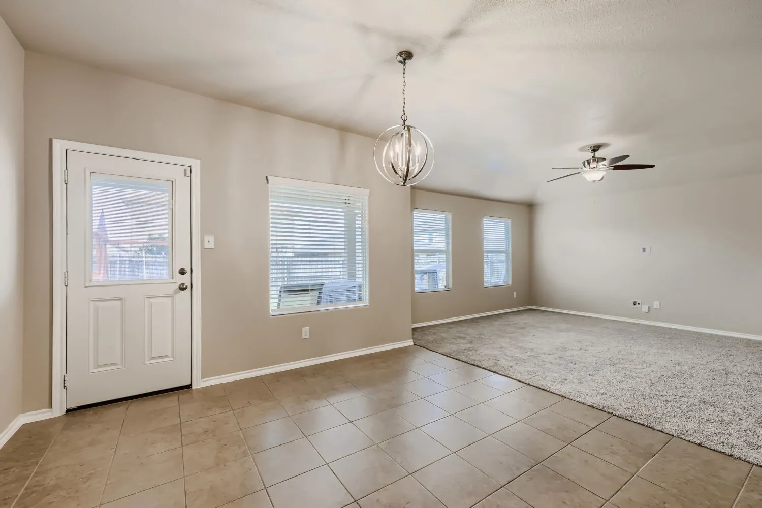 Open concept living space featuring tile flooring, a contemporary spherical chandelier, and a ceiling fan