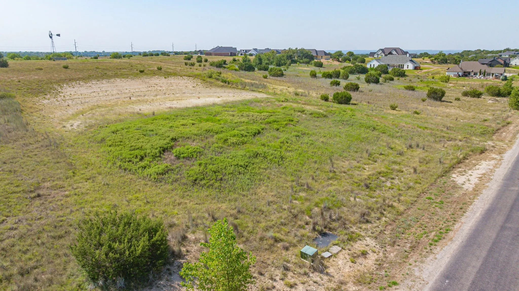 Expansive land parcel featuring natural grasses and scattered shrubbery