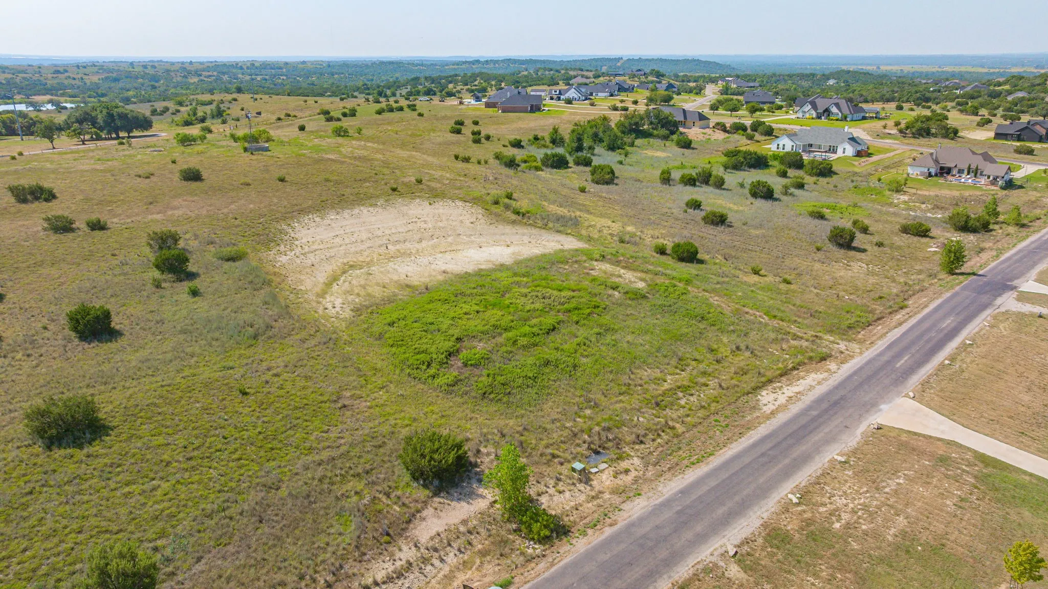 Expansive land parcel featuring existing road infrastructure and surrounding residences
