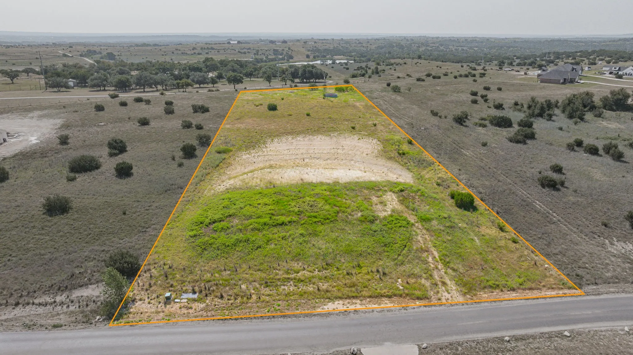 Expansive undeveloped land parcel with a paved road frontage