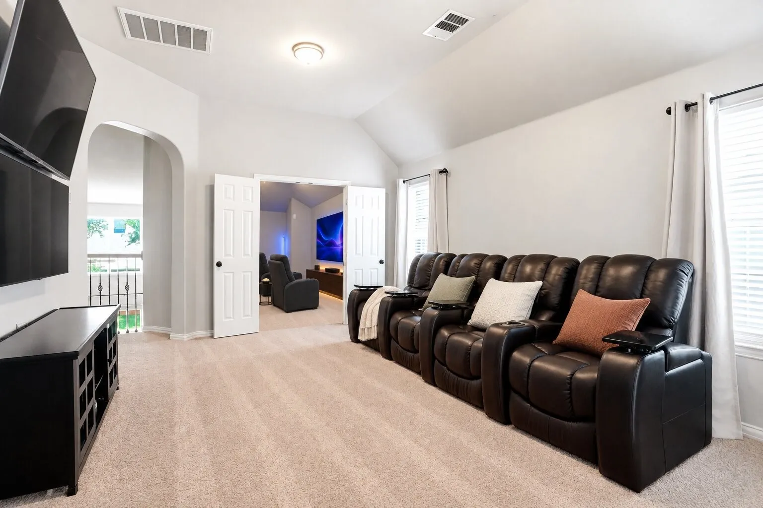 Additional view of the media room showcasing its generous size, vaulted ceiling, and flexible layout for movie nights, gaming, or a home entertainment space. Photos have been AI enhanced for presentation; no material property features were altered.