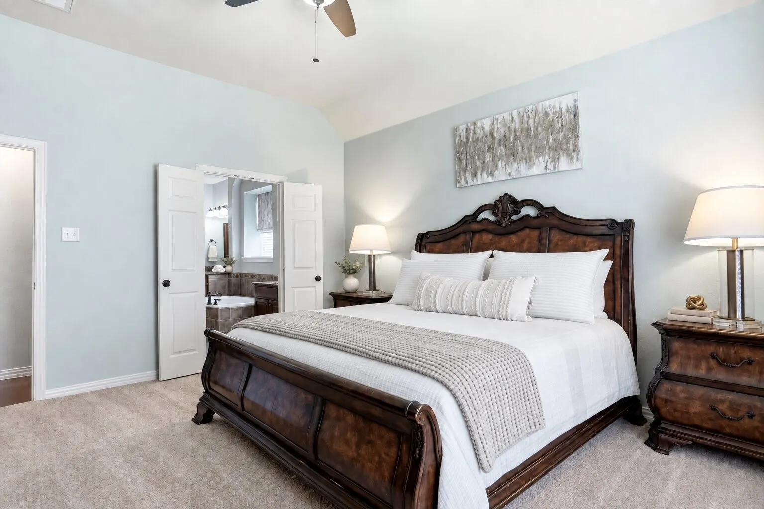 Primary suite featuring abundant natural light and direct access to the spacious ensuite bathroom through double doors. Photos have been AI enhanced for presentation; no material property features were altered.