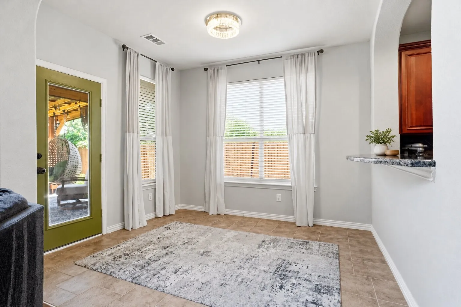 Bright breakfast area featuring large windows, abundant natural light, and direct access to the covered outdoor living space. Photos have been AI enhanced for presentation; no material property features were altered.