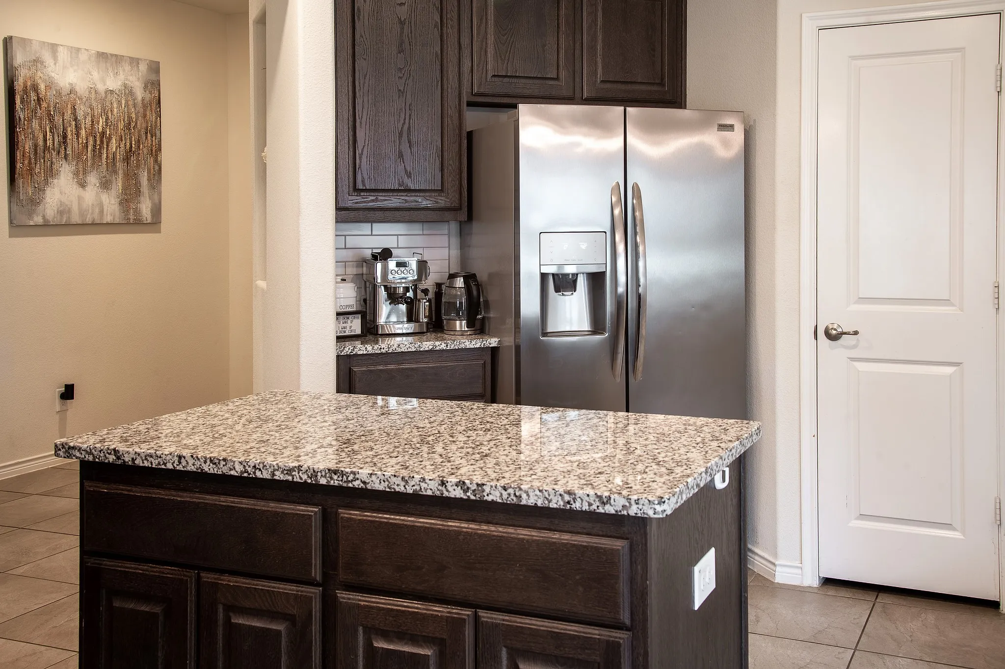 Kitchen island with a granite countertop and dark wood cabinetry