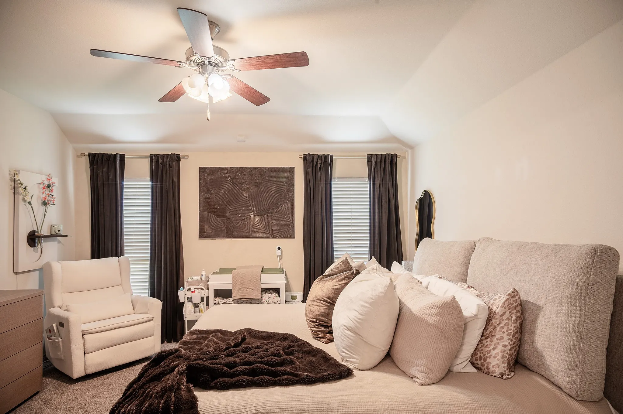 Spacious room featuring a ceiling fan with integrated lighting, two windows with blinds and dark drapes, and a neutral color palette