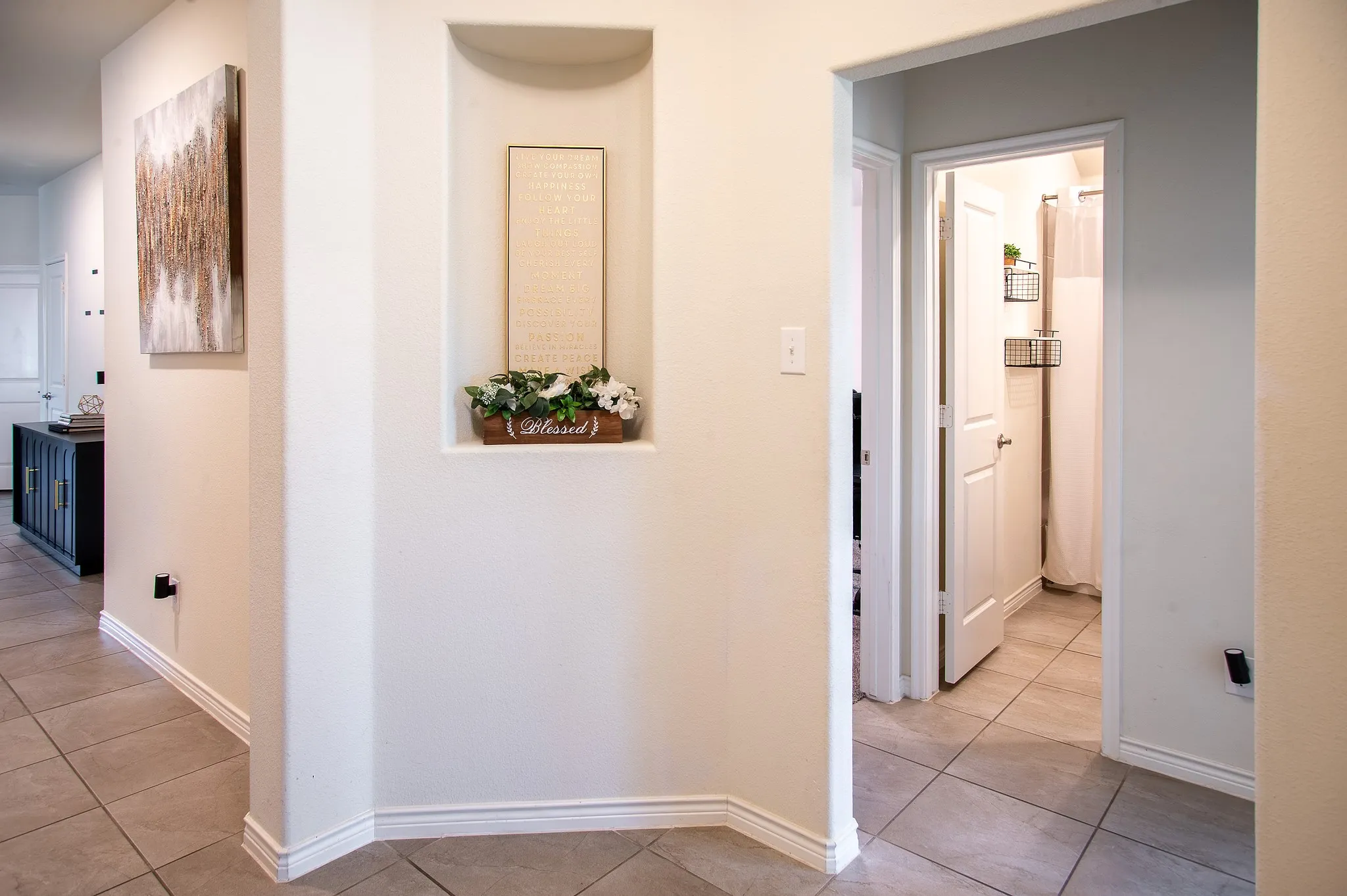 Recessed wall niche, tile flooring, white baseboards, and neutral wall tones