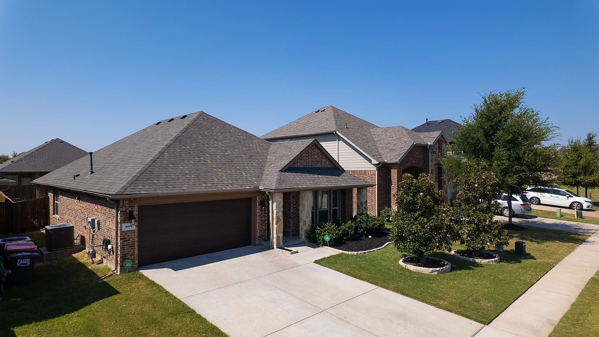 Brick and stone facade residence featuring a dark asphalt shingle roof