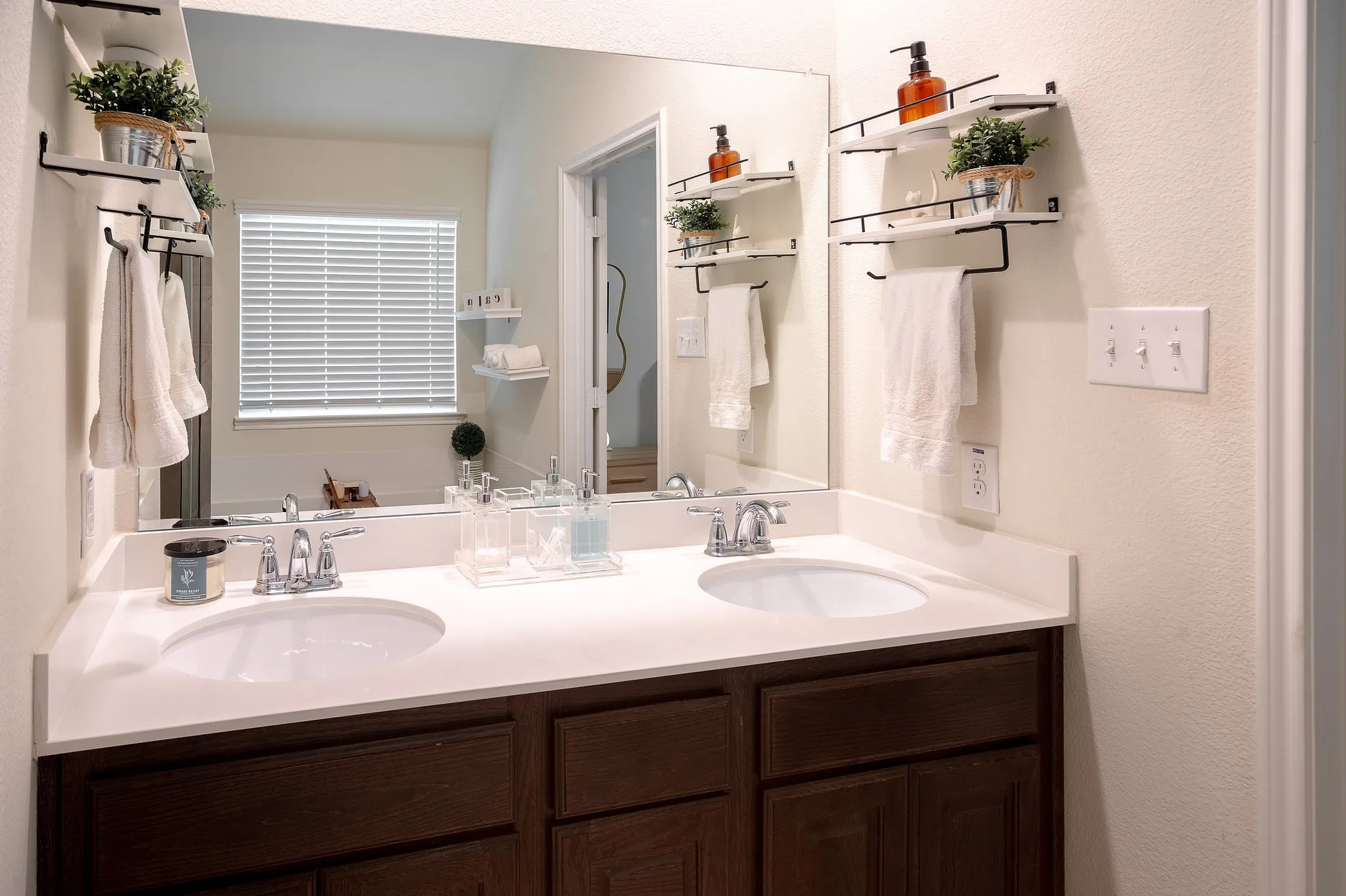 Bathroom featuring a dual sink vanity with white countertops and dark wood-finish cabinetry