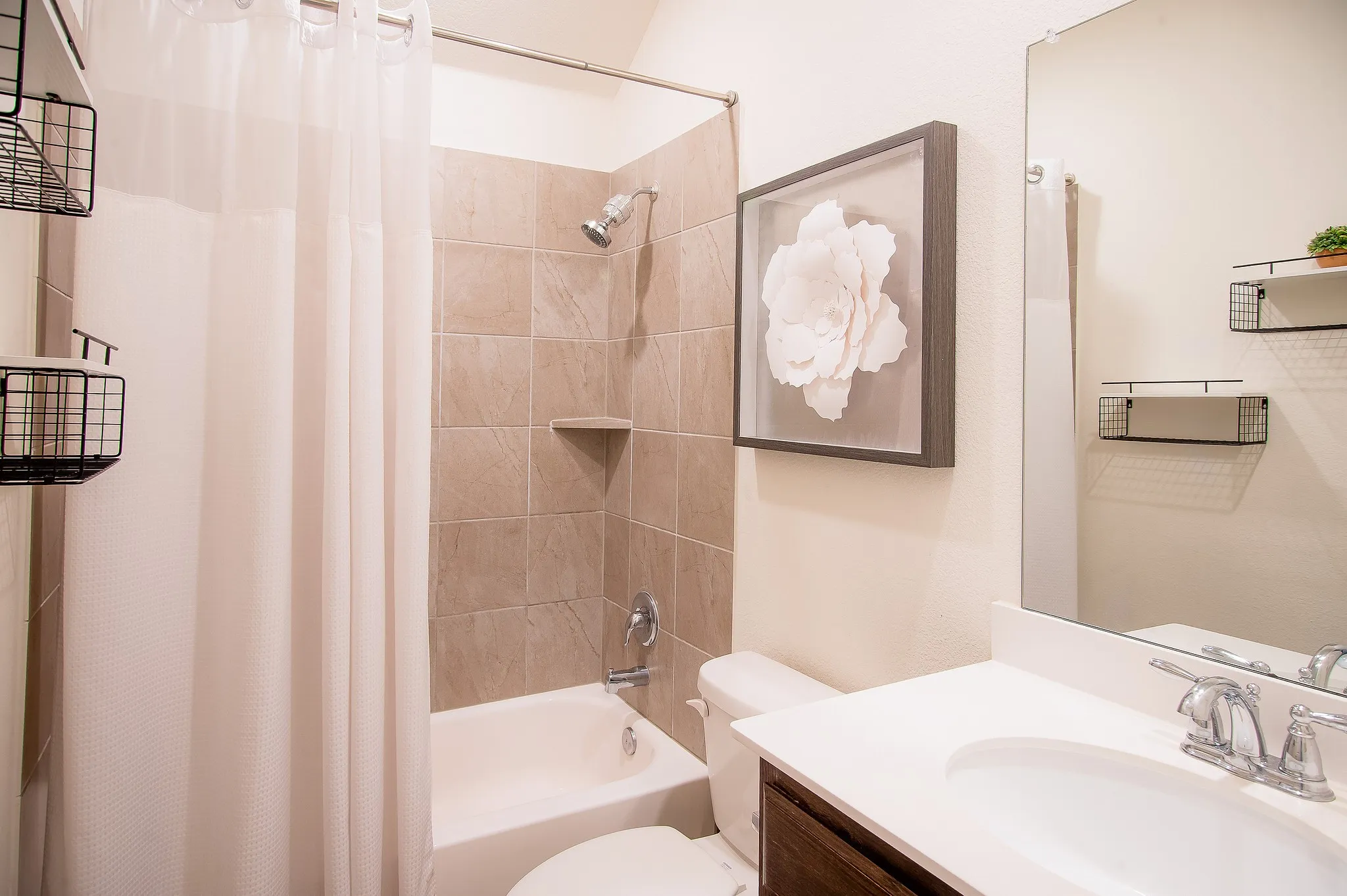 Bathroom featuring a white vanity with an integrated sink, polished chrome faucet, and a large mirror
