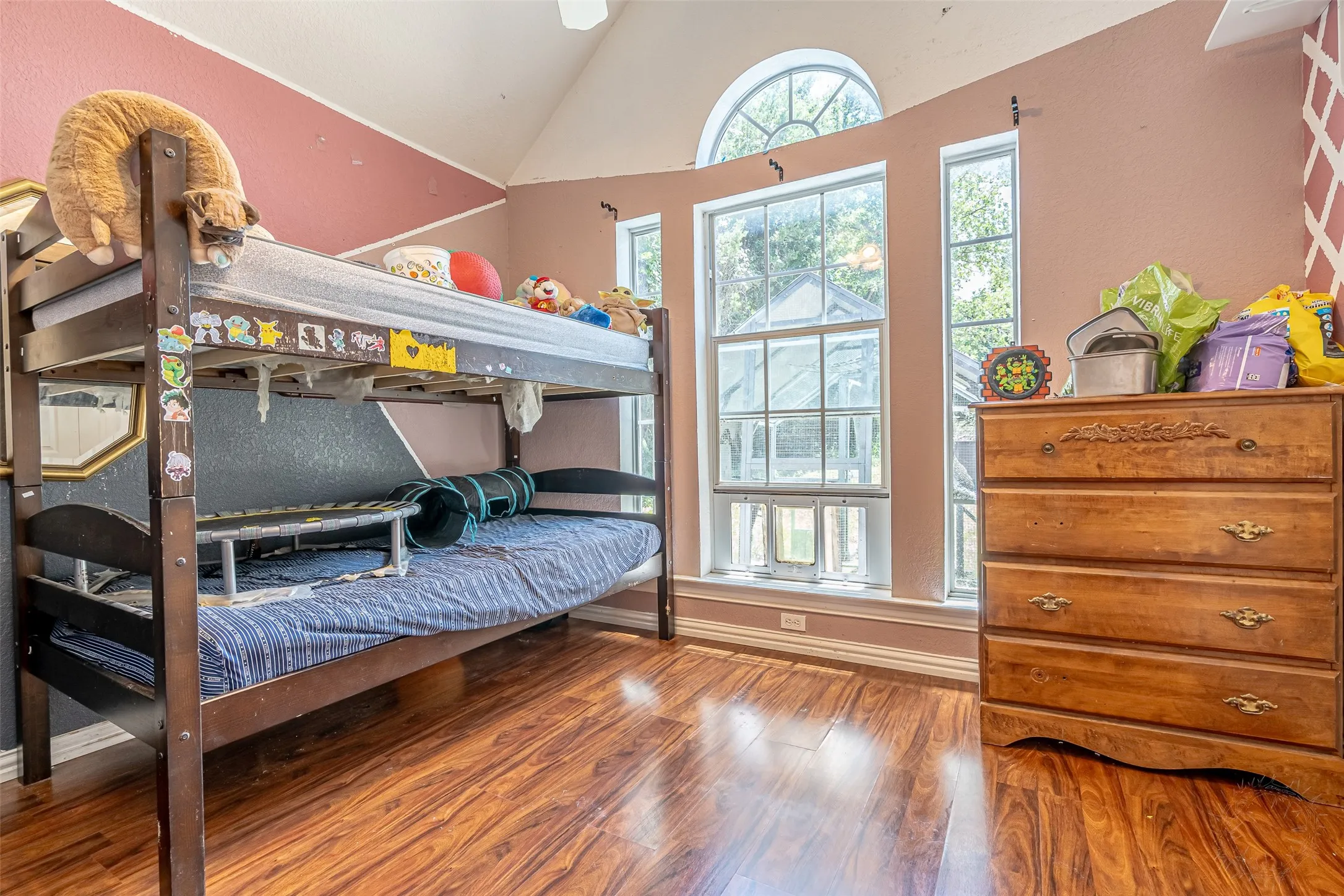 Spacious interior room featuring wood-finish flooring, ceiling fan, and large windown
