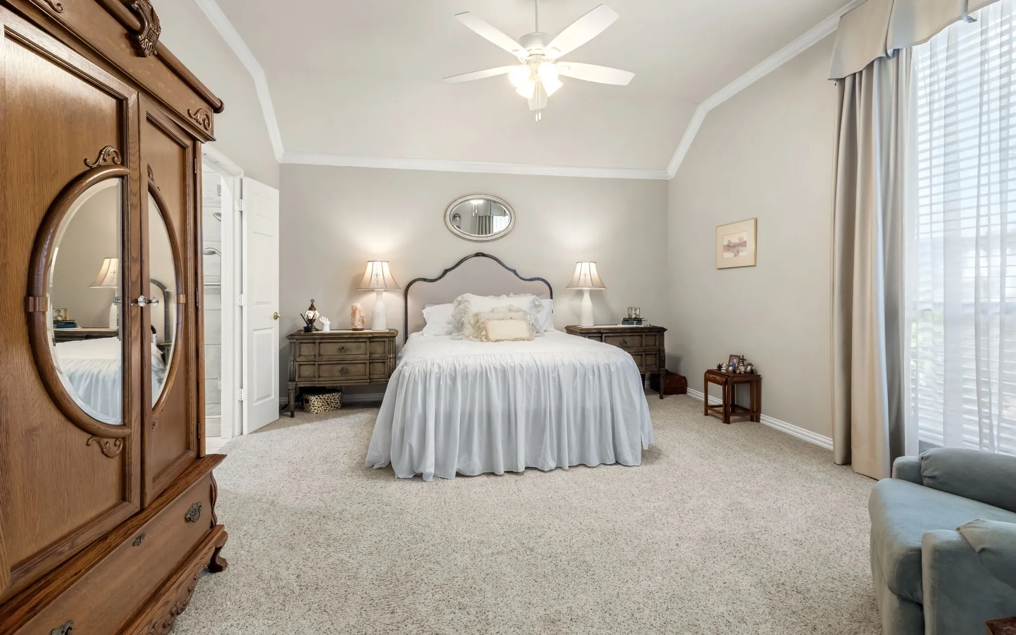Vaulted ceiling with a ceiling fan, carpeted flooring, and a large window with blinds and curtains