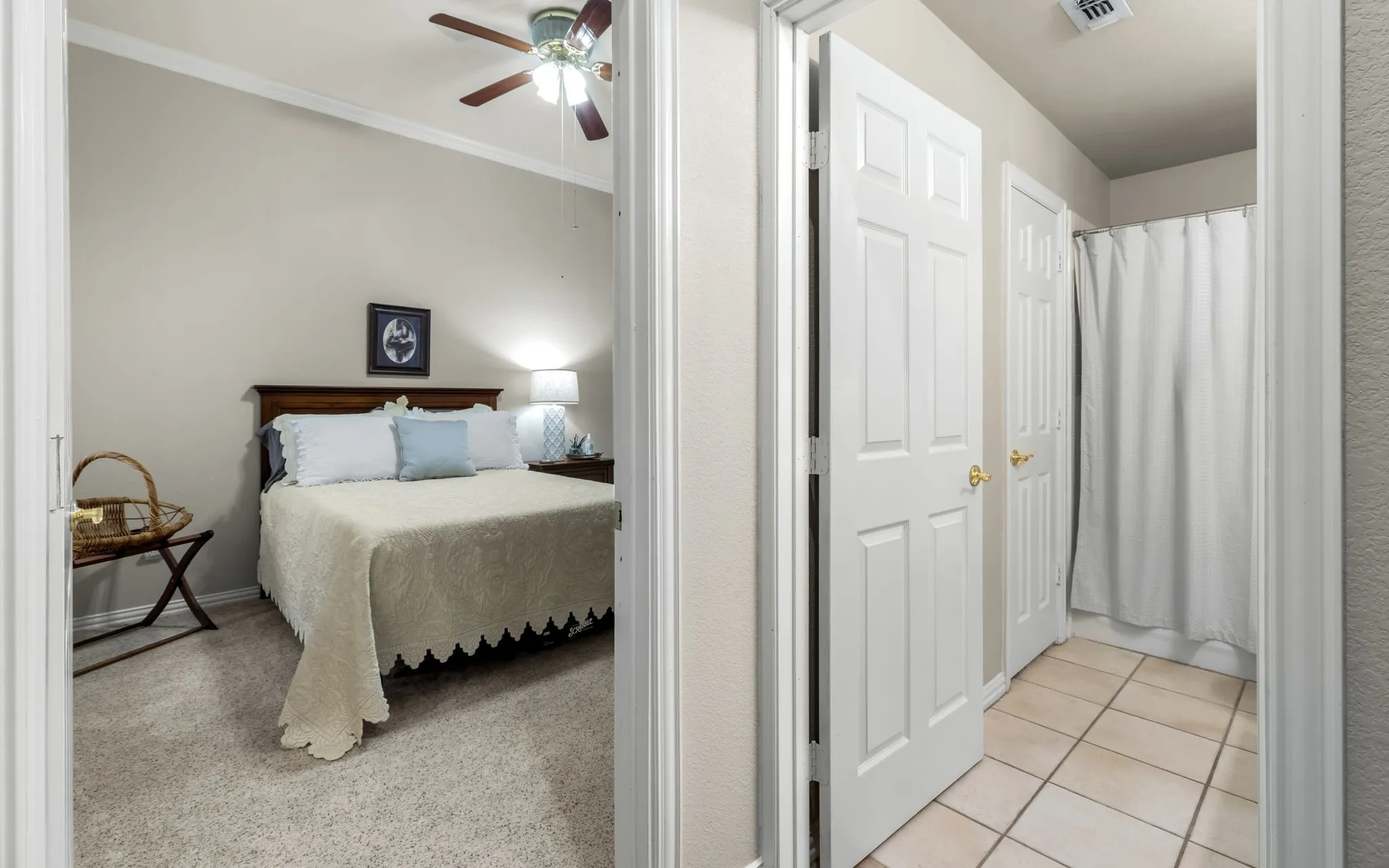 Carpeted bedroom with a ceiling fan, crown molding, and a wood-finish headboard