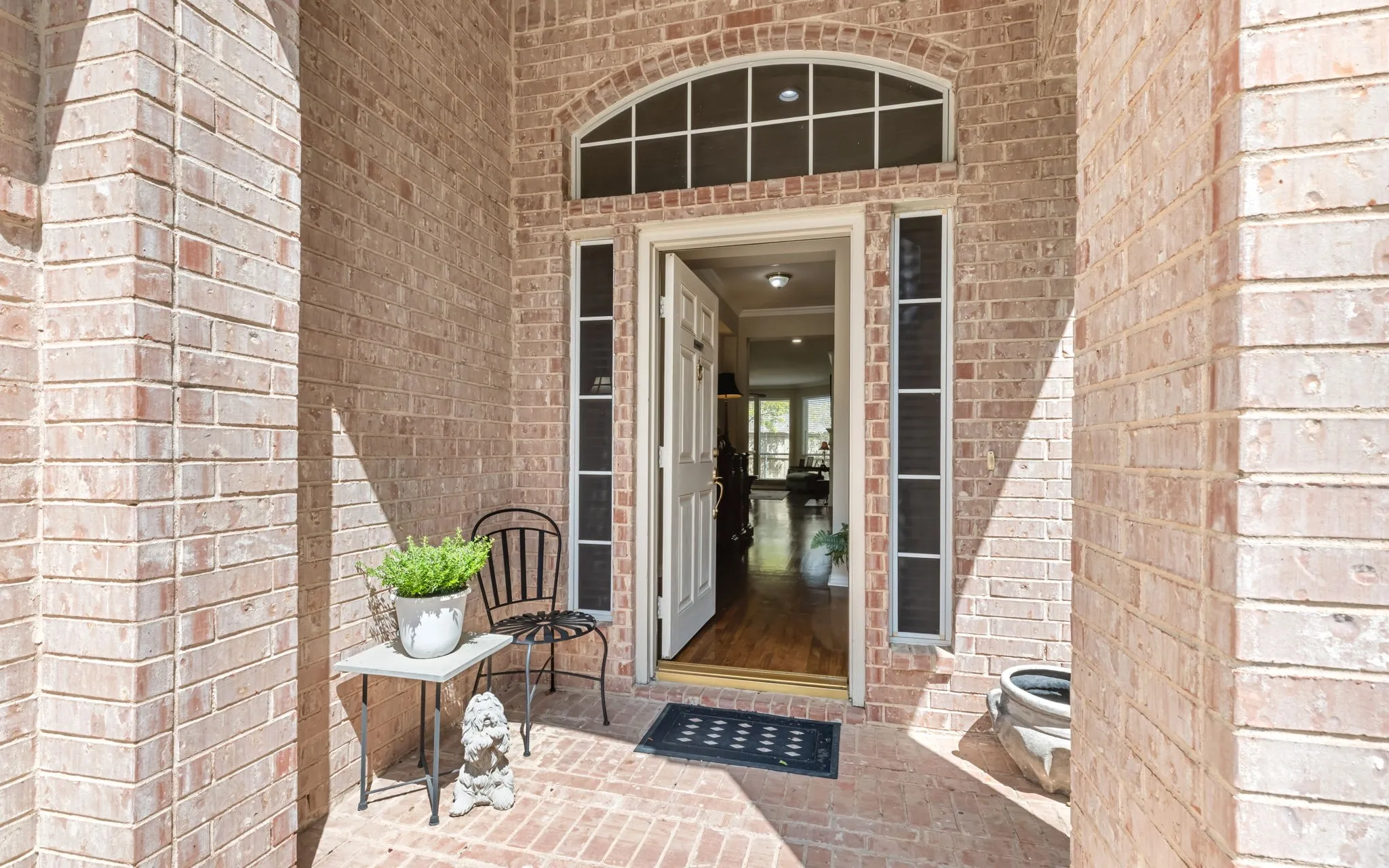 Brick exterior with a covered entry, arched transom window, and a paneled front door