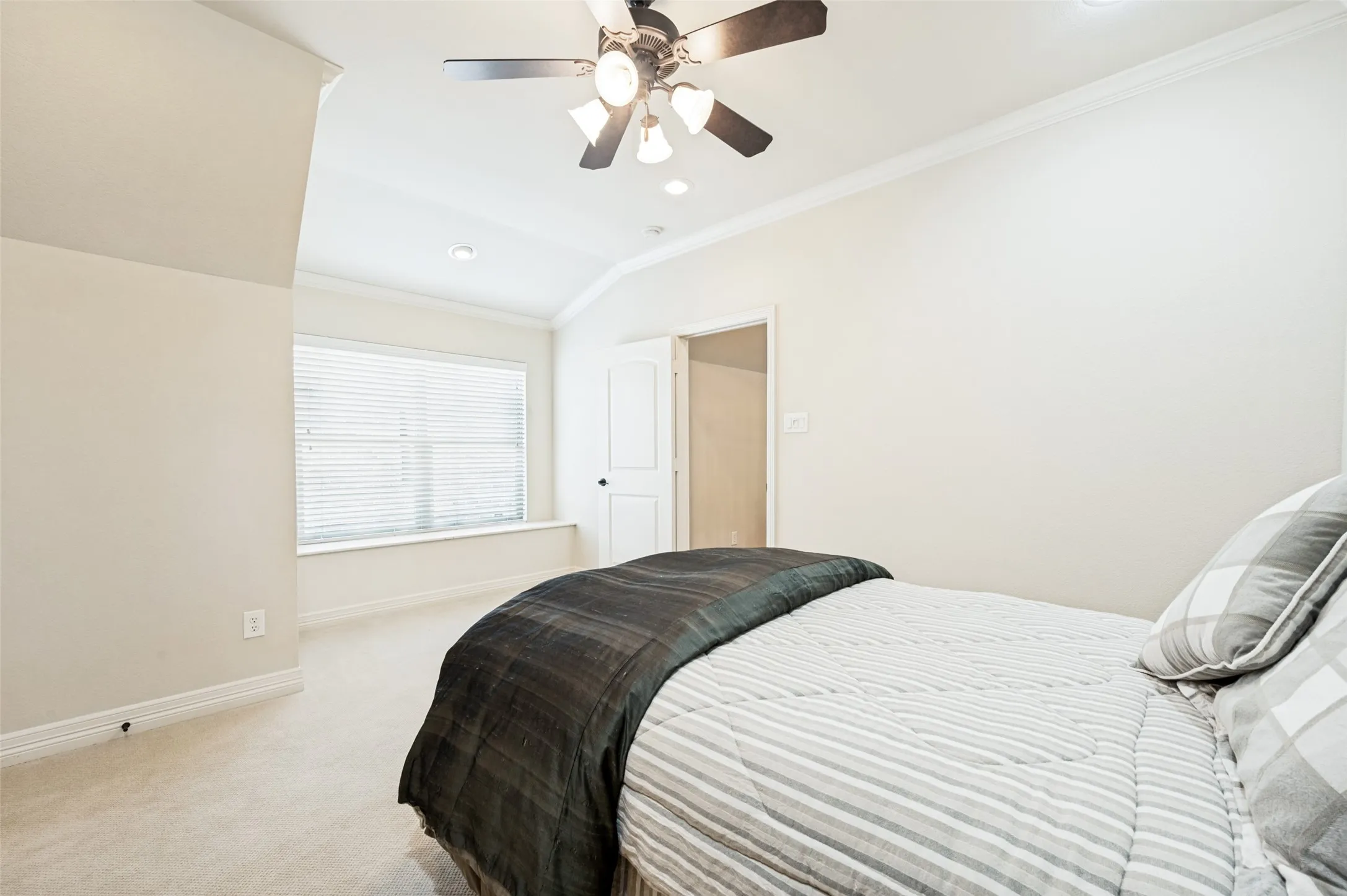 Carpeted bedroom featuring a vaulted ceiling with a ceiling fan, recessed lighting, and crown molding