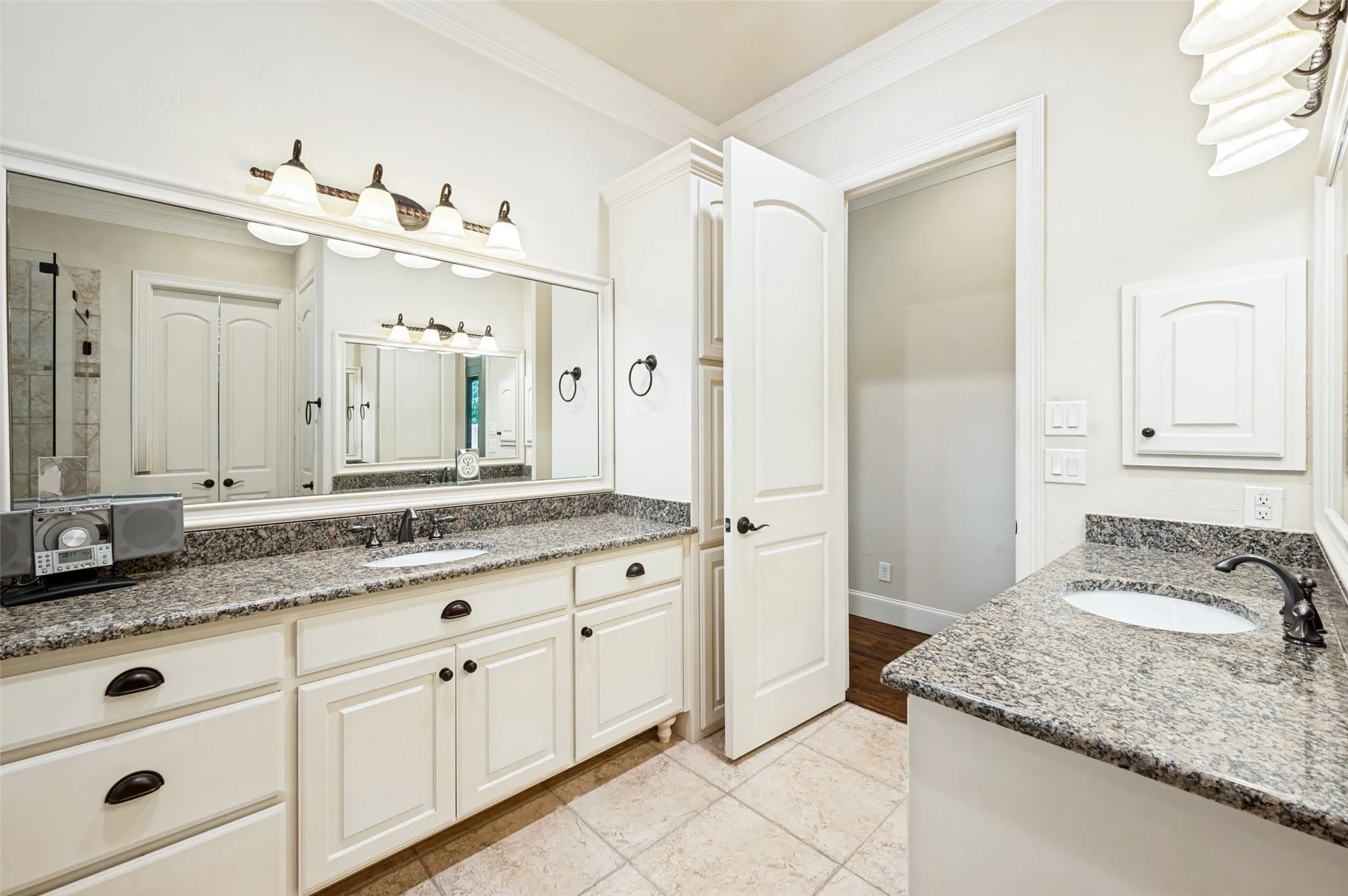 Dual vanity with granite countertops, undermount sinks, and white cabinetry