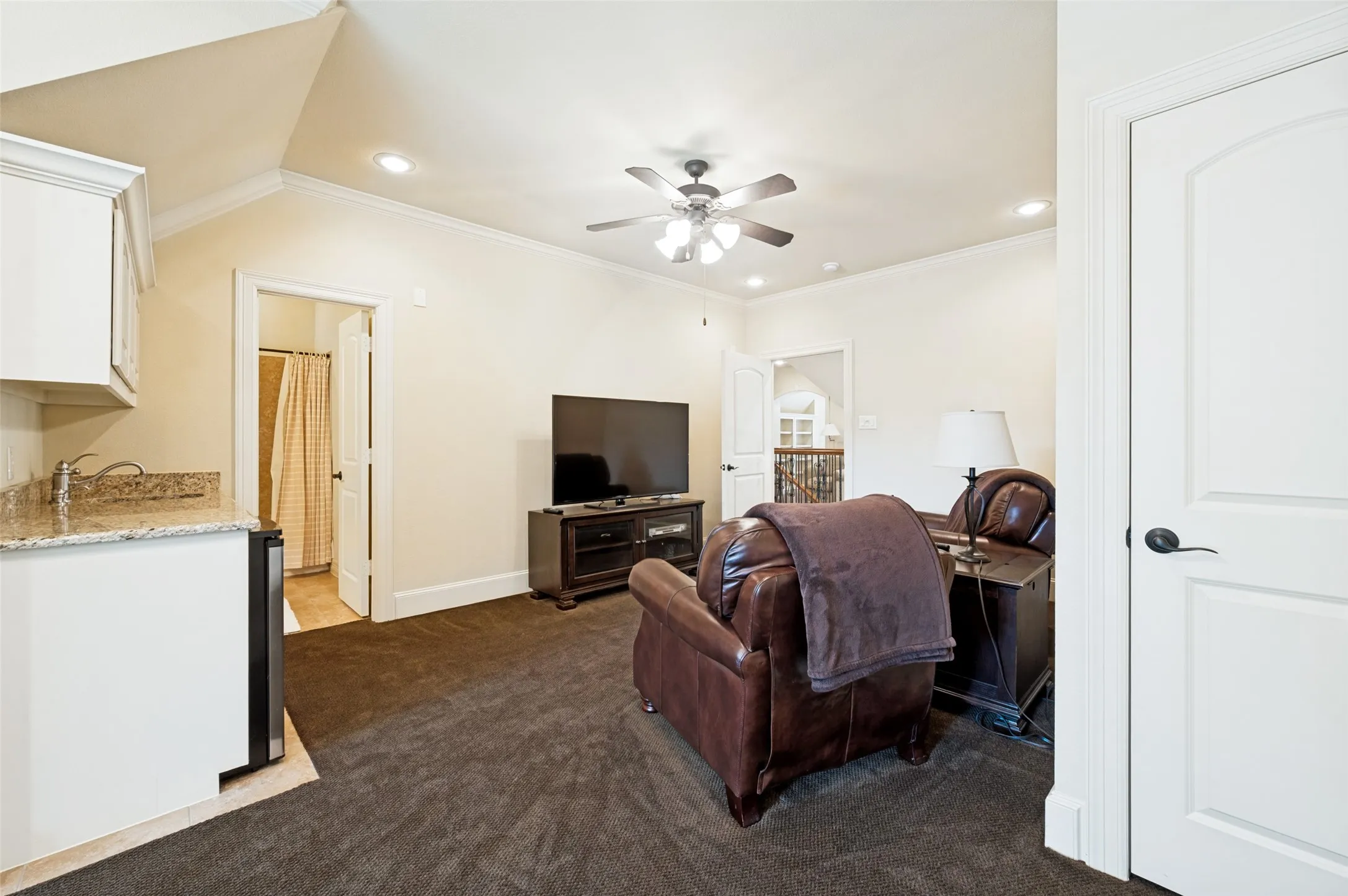 Carpeted bonus room featuring a built-in wet bar with granite countertop, recessed lighting, ceiling fan, and access to a full bathroom