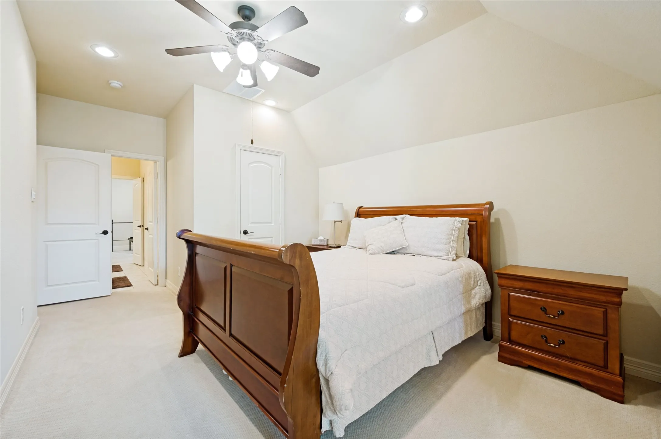 Carpeted room with vaulted ceilings and recessed lighting