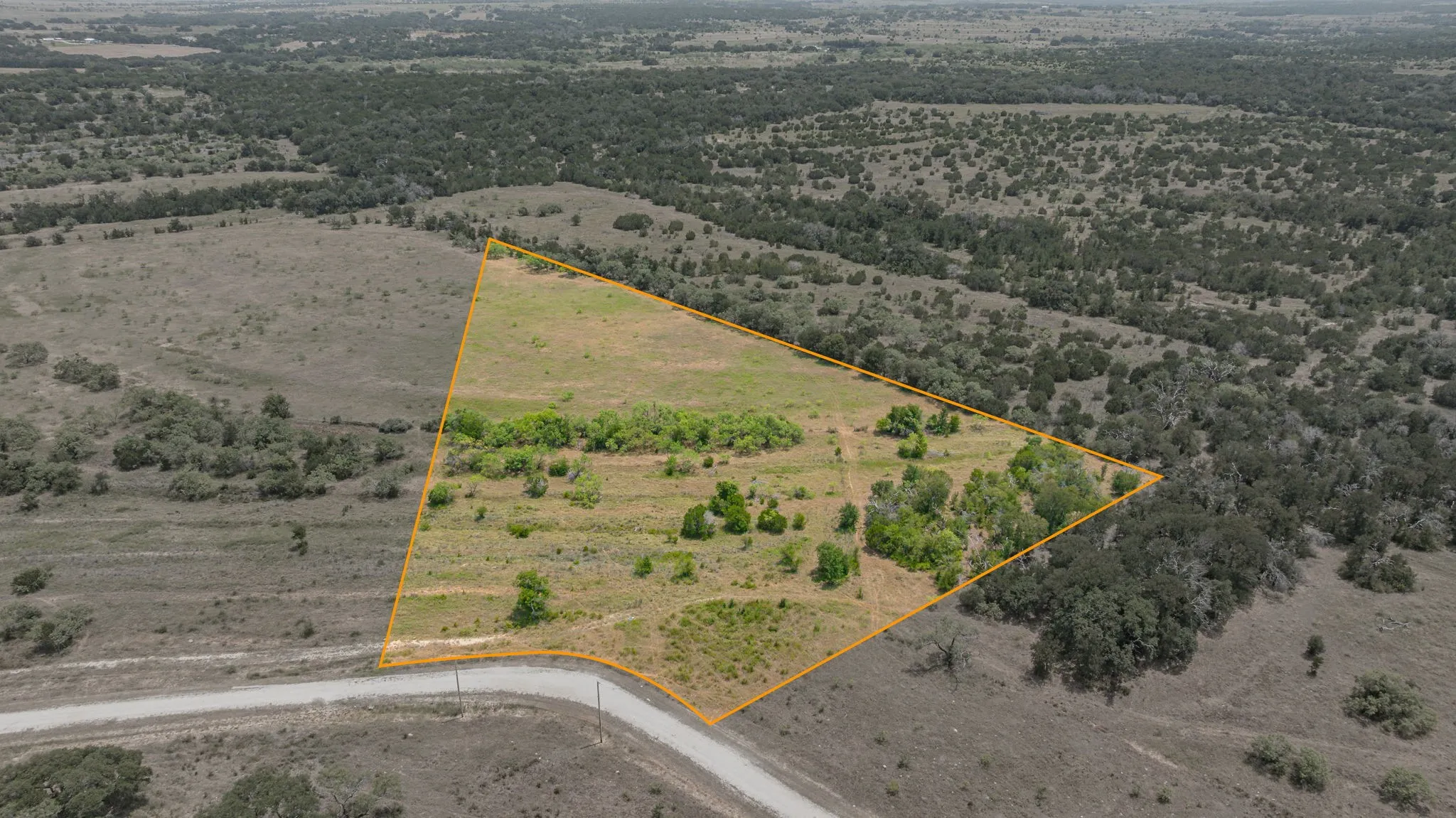Expansive undeveloped lot with a mix of grassland and mature trees