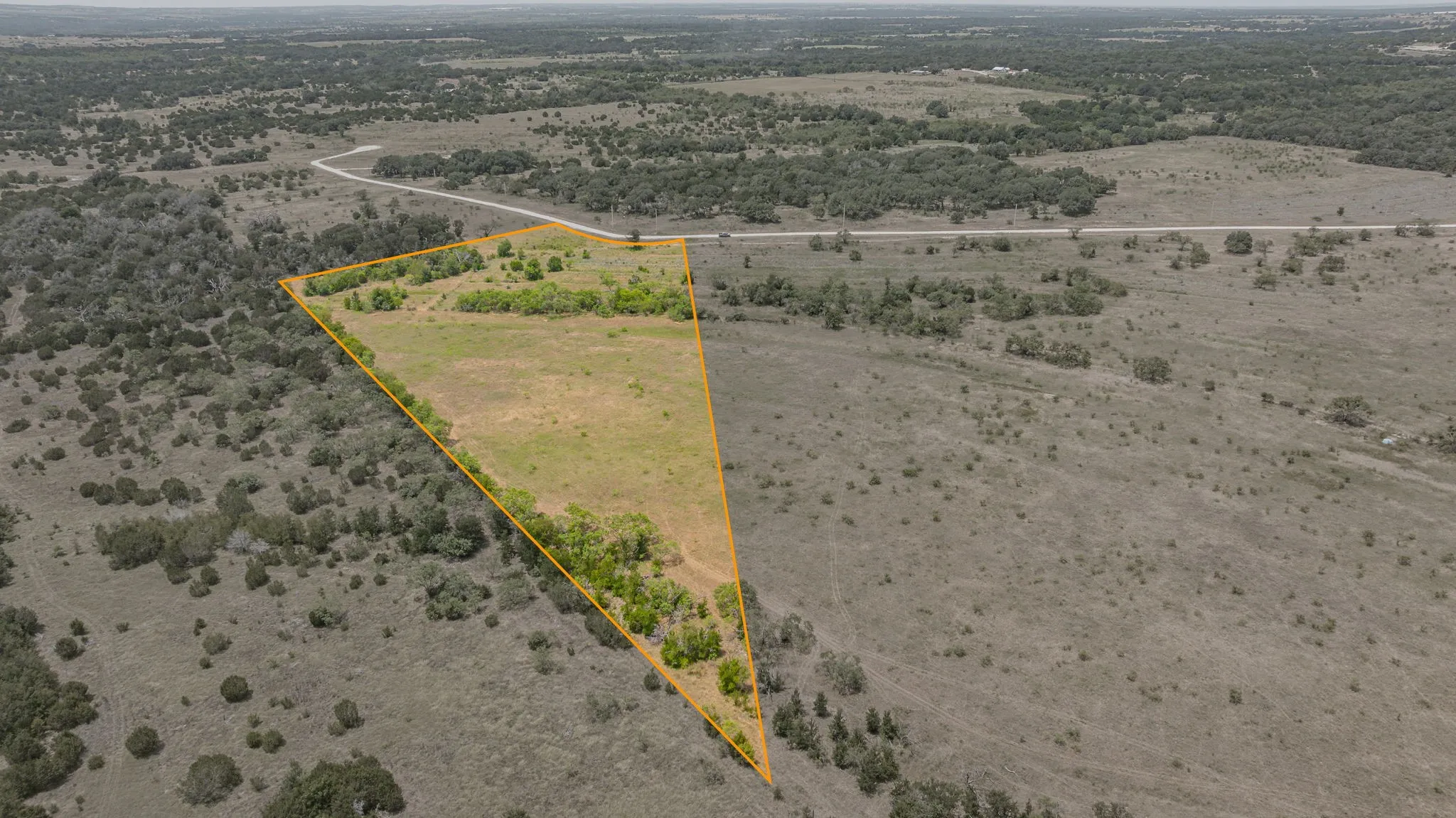 Expansive triangular parcel featuring varied terrain including open clearings and natural tree coverage