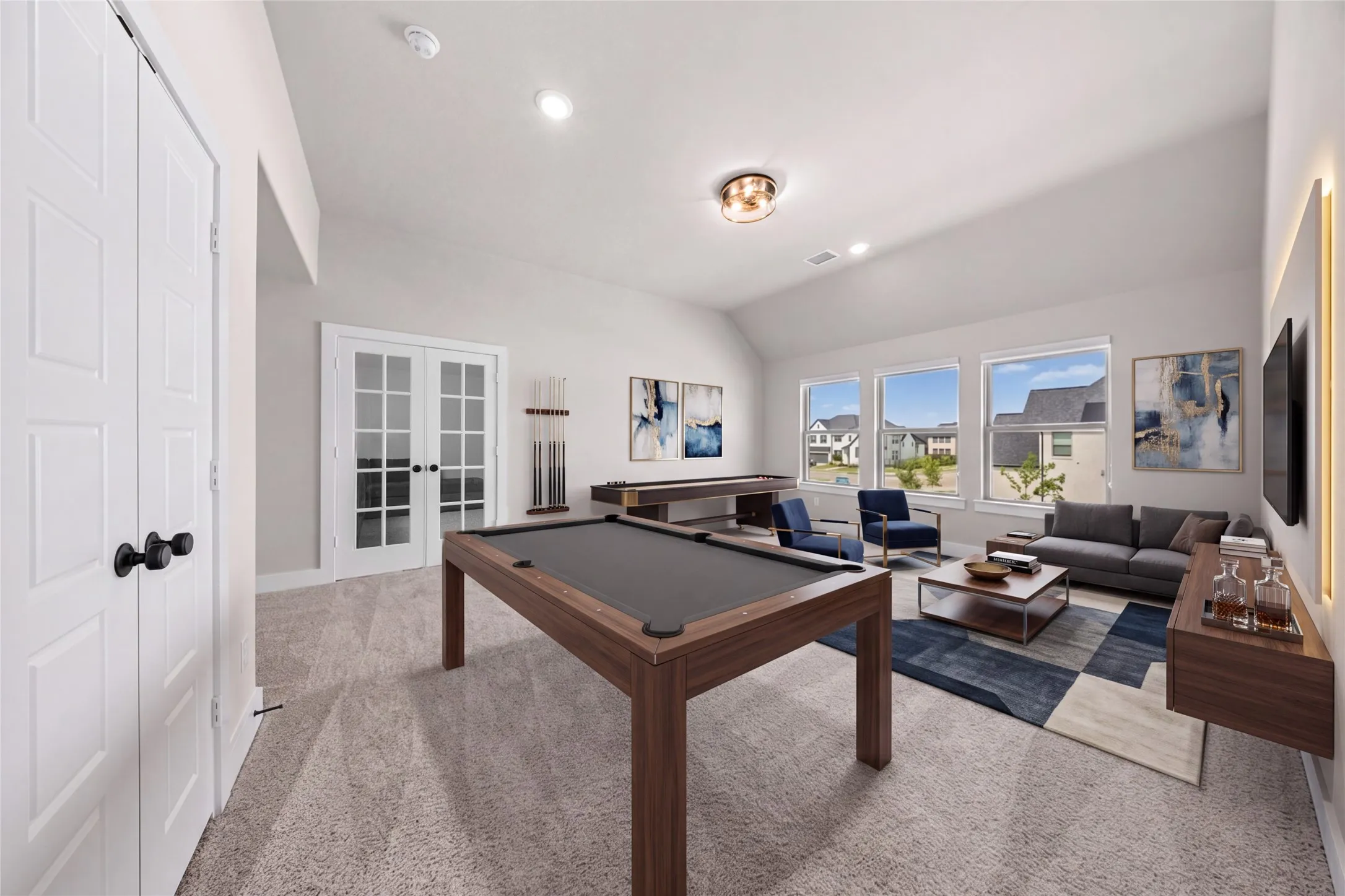 Vaulted ceiling with recessed lighting, large windows, French doors, and carpet flooring