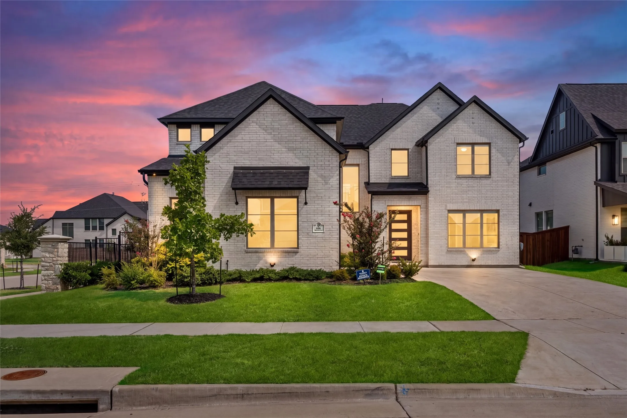 Contemporary facade with light brick and dark trim, gabled rooflines, and a concrete driveway