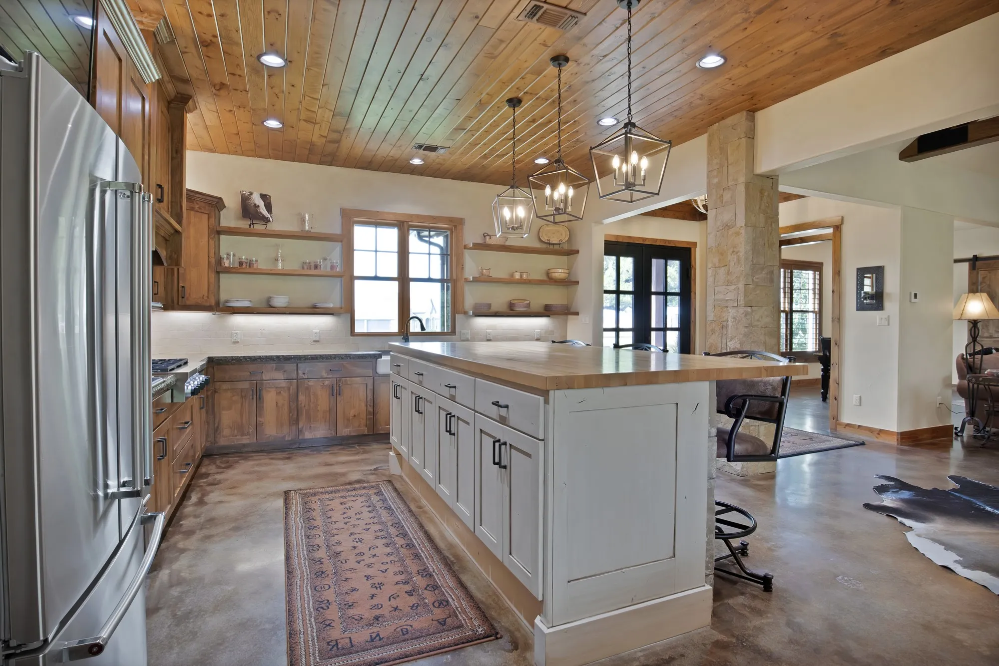 Gourmet kitchen featuring a wood-planked ceiling, recessed lighting, and a substantial island with seating