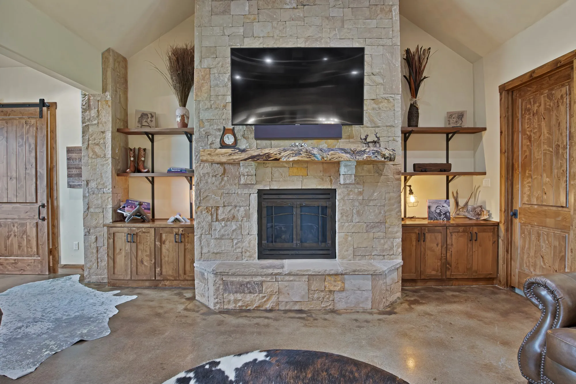 Stone-clad fireplace with a natural wood mantel