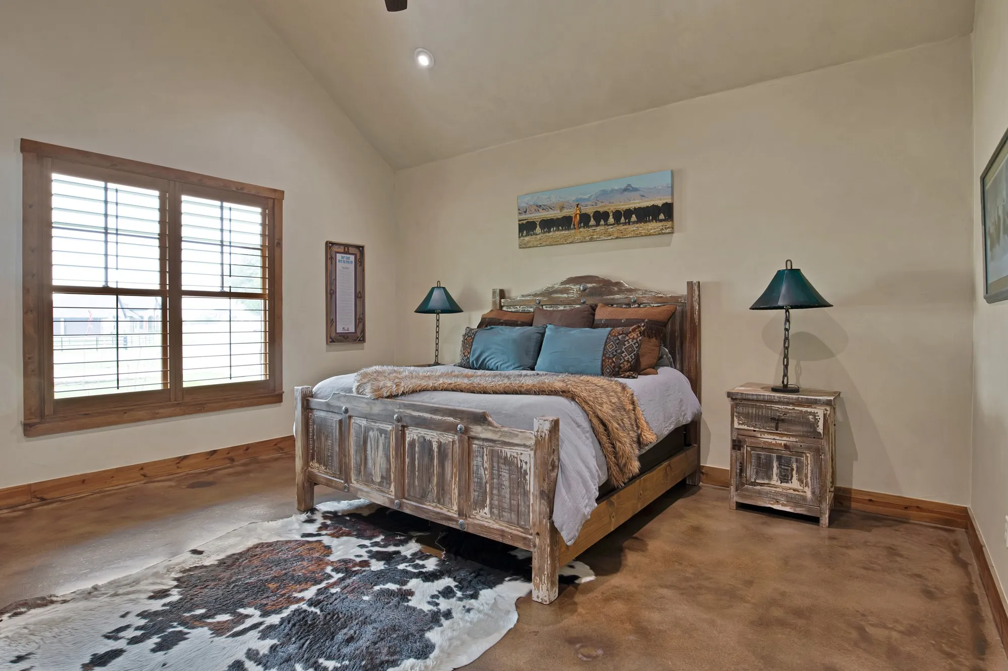 Spacious primary bedroom featuring a rustic wood-frame bed, wood-finish flooring, and recessed ceiling lighting
