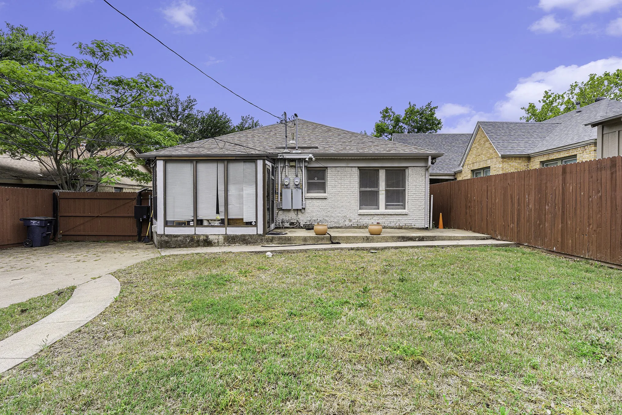 Rear view of house with a patio and a lawn
