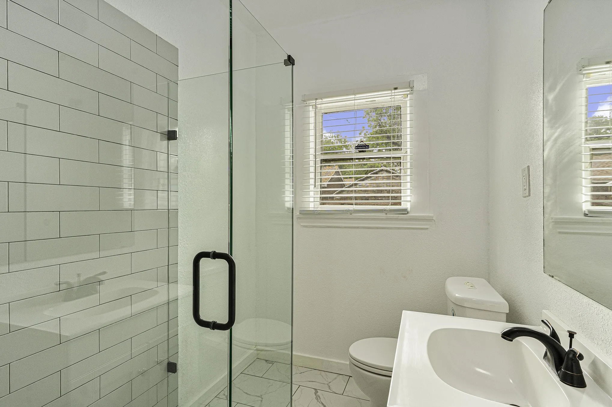 Bathroom with sink, tile patterned flooring, toilet, and a wealth of natural light