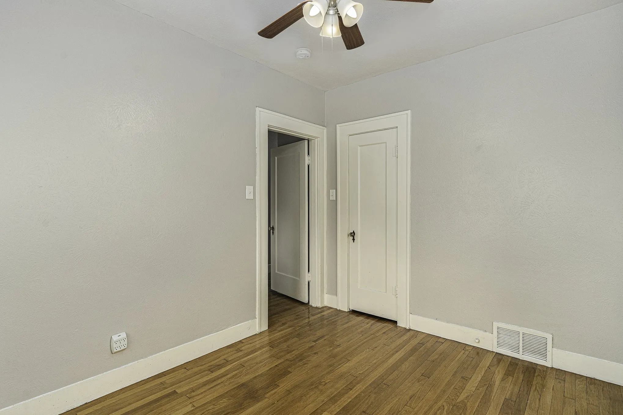 Unfurnished room featuring ceiling fan and dark hardwood / wood-style flooring