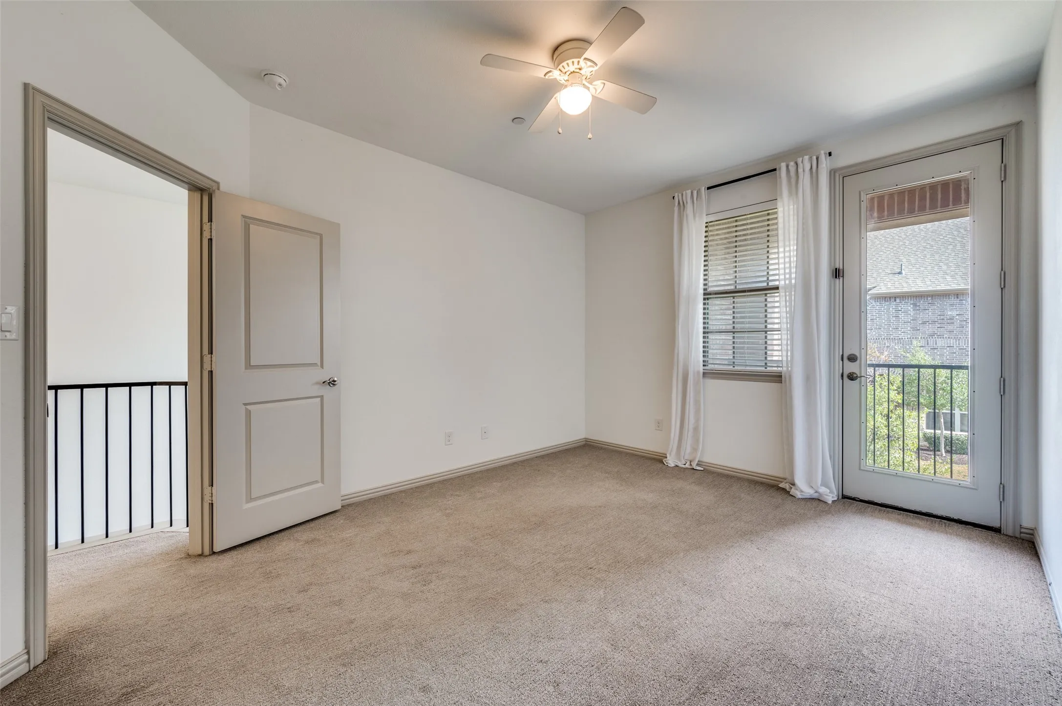Empty upstairs bedroom or flex room featuring ceiling fan, light carpet, natural light from windows, and neutral paint, offering options for a secondary bedroom, home office, guest room, nursery, or playroom in this McKinney Texas townhome, ideal for buyers needing flexible space in a family friendly neighborhood.