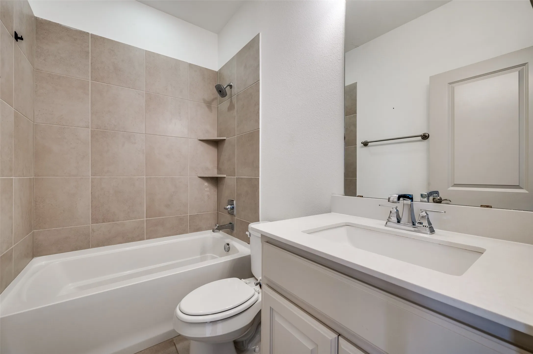 Full bathroom with vanity, shower tub combination, neutral tile surround, and simple clean design, serving secondary bedrooms and adding everyday functionality for residents searching for a McKinney TX townhome with multiple full bathrooms in a Collin County suburban neighborhood