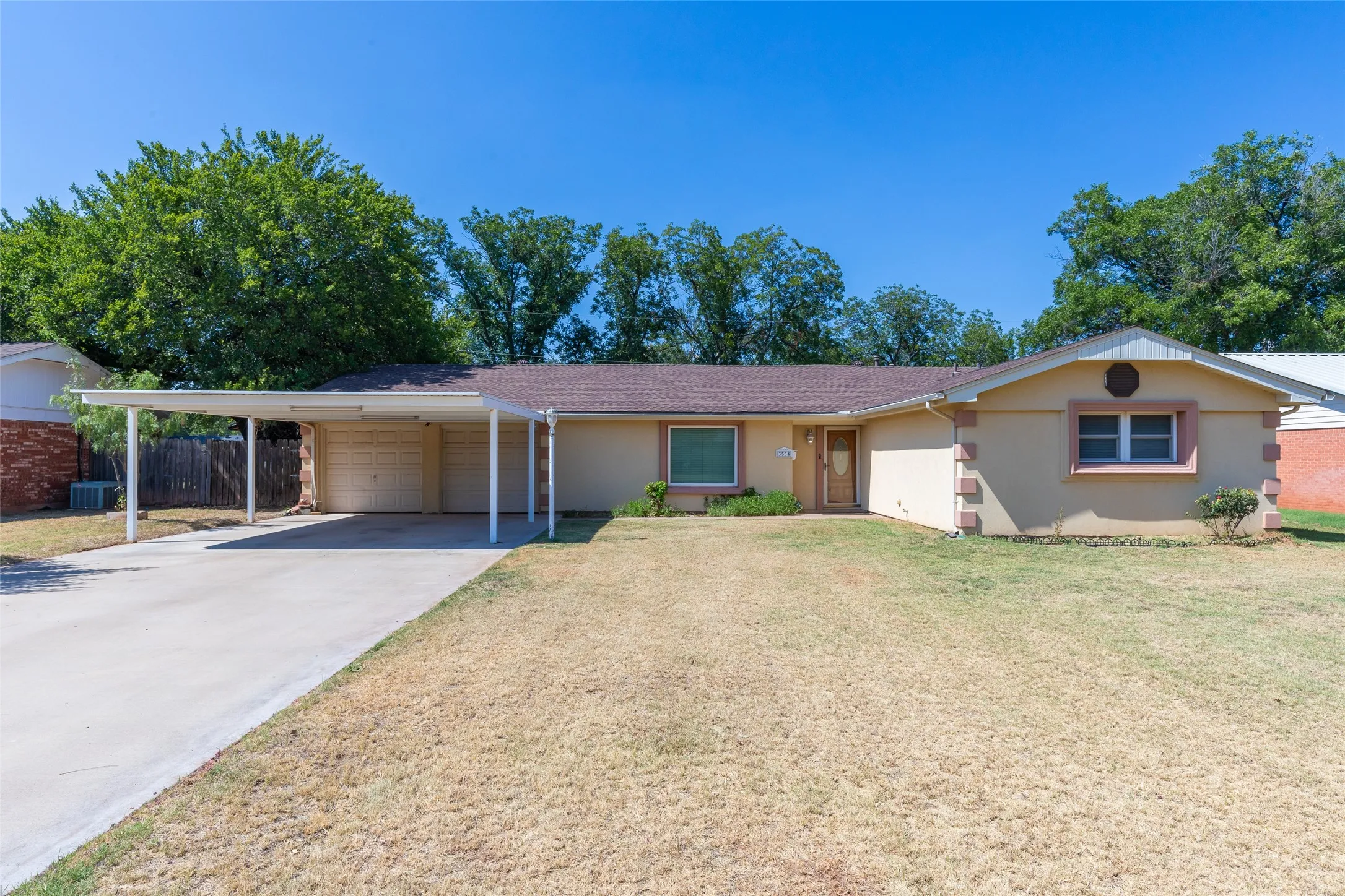Ranch-style exterior with a carport and an attached garage