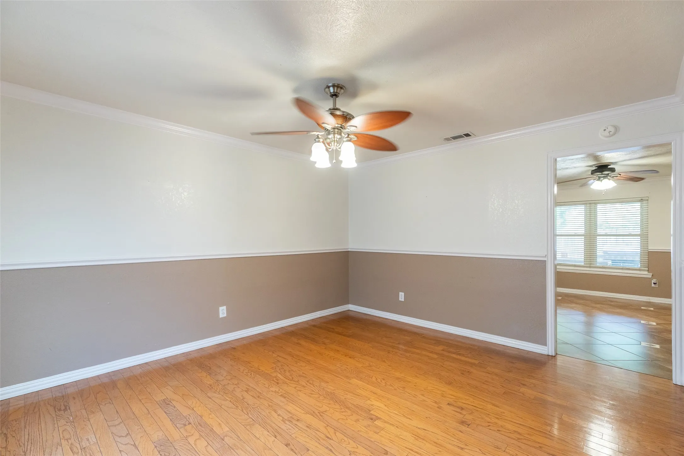 Hardwood-finish flooring with a two-tone wall treatment and white trim