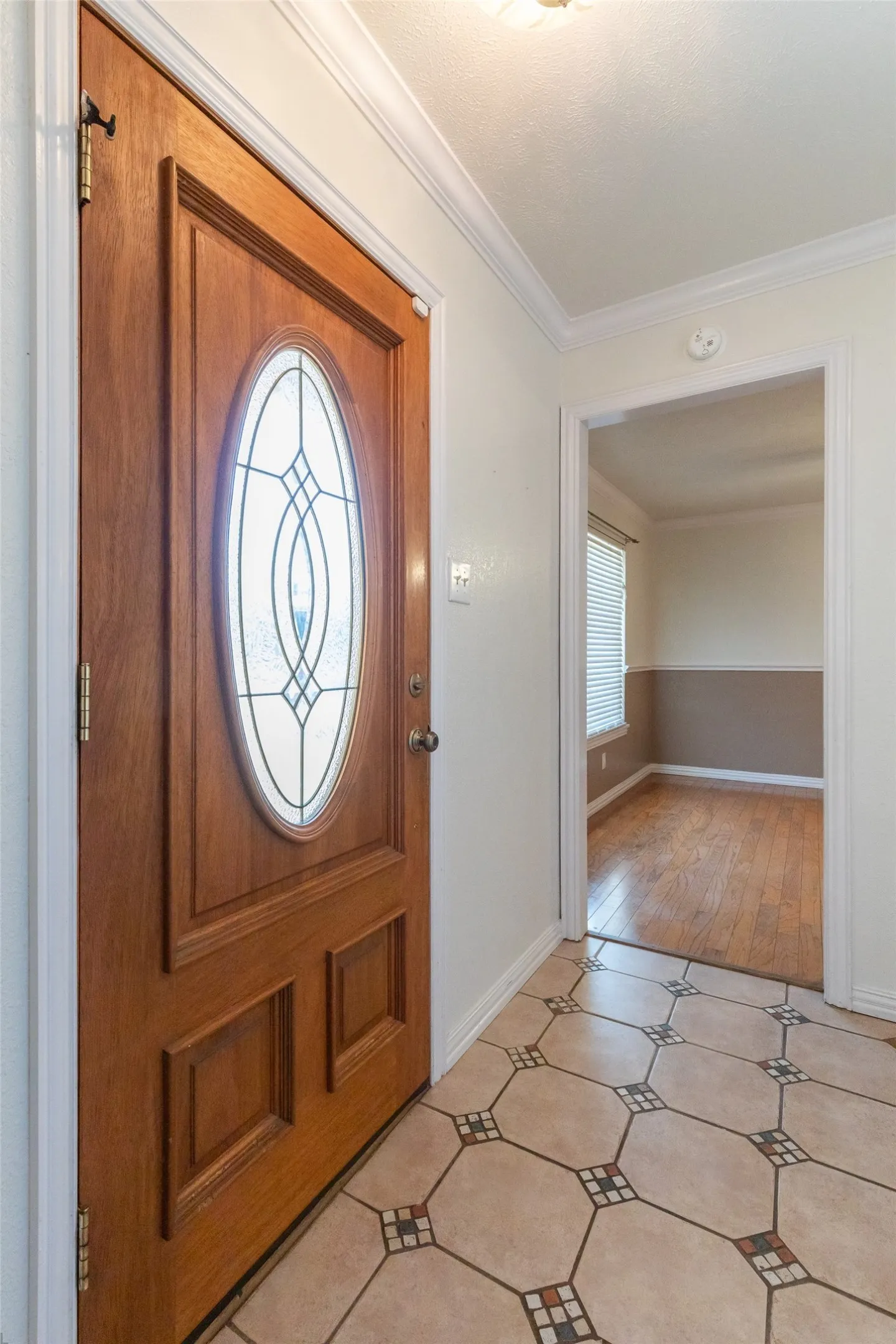 Rich wood-finish entry door with an oval decorative glass insert