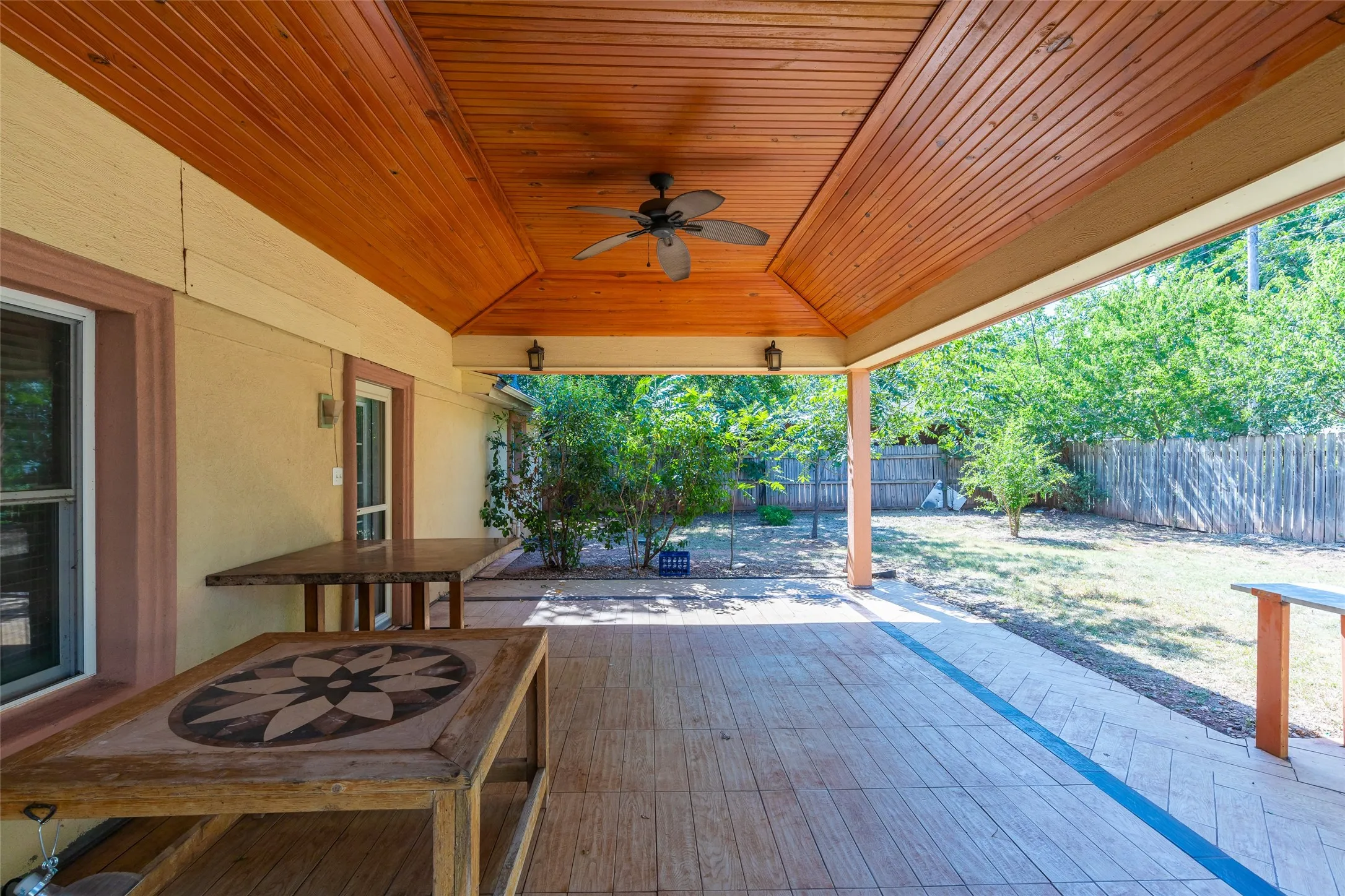 Spacious covered patio featuring a wood-finish tongue-and-groove ceiling, ceiling fan, and recessed lighting