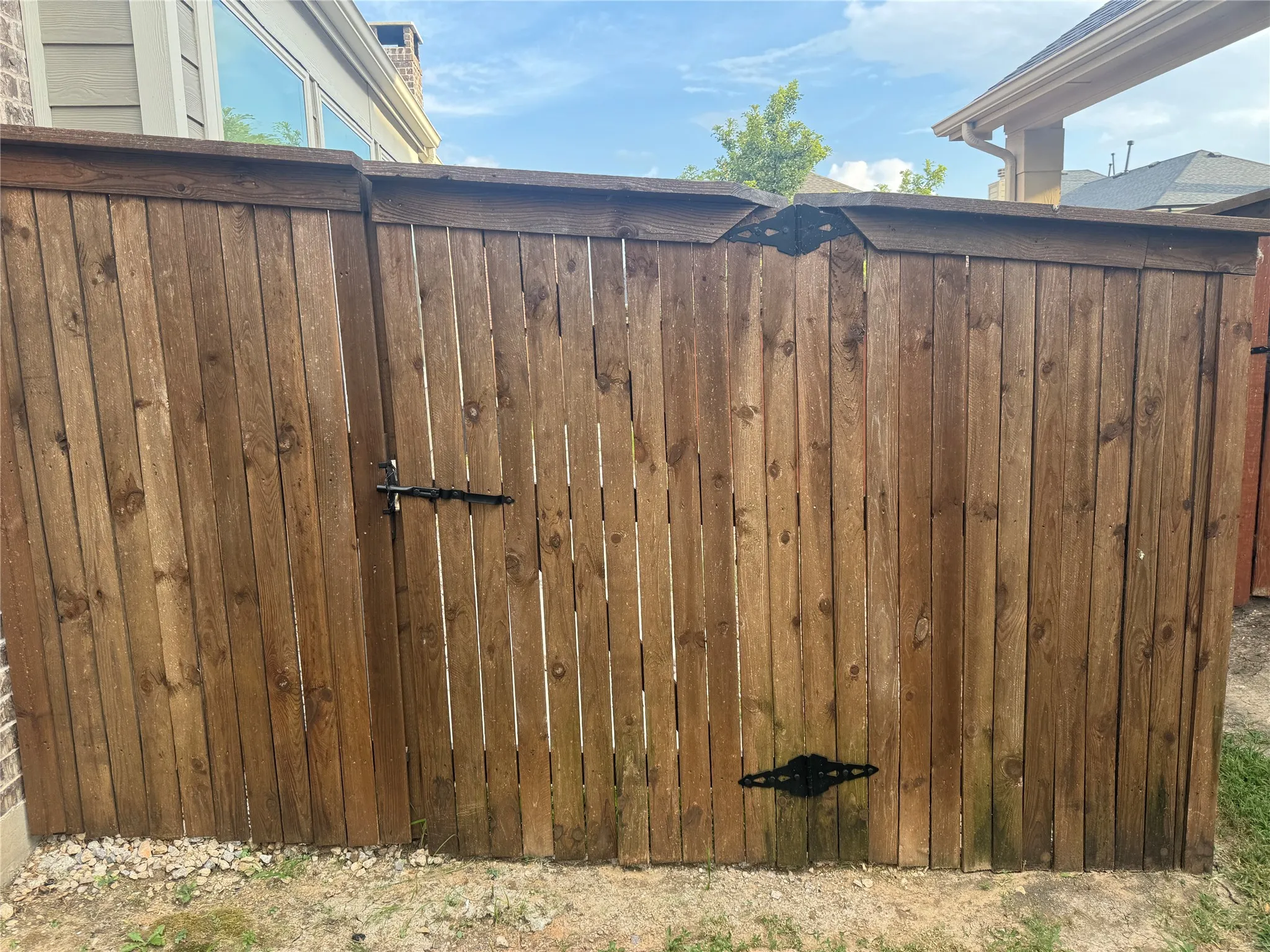 Wood-paneled fencing with a hinged gate